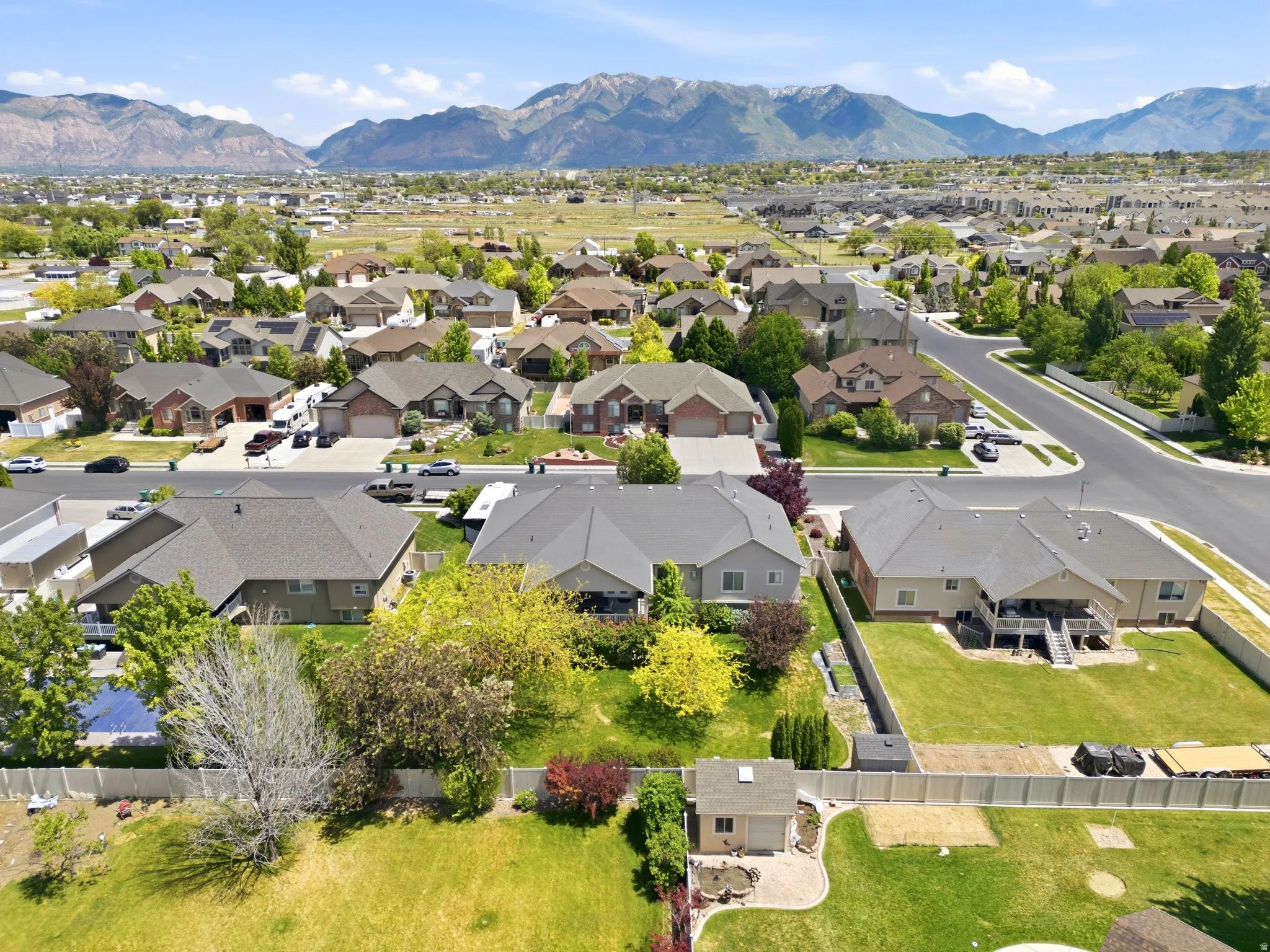 Expansive suburban neighborhood featuring a variety of residential properties, paved streets, and mountainous backdrops