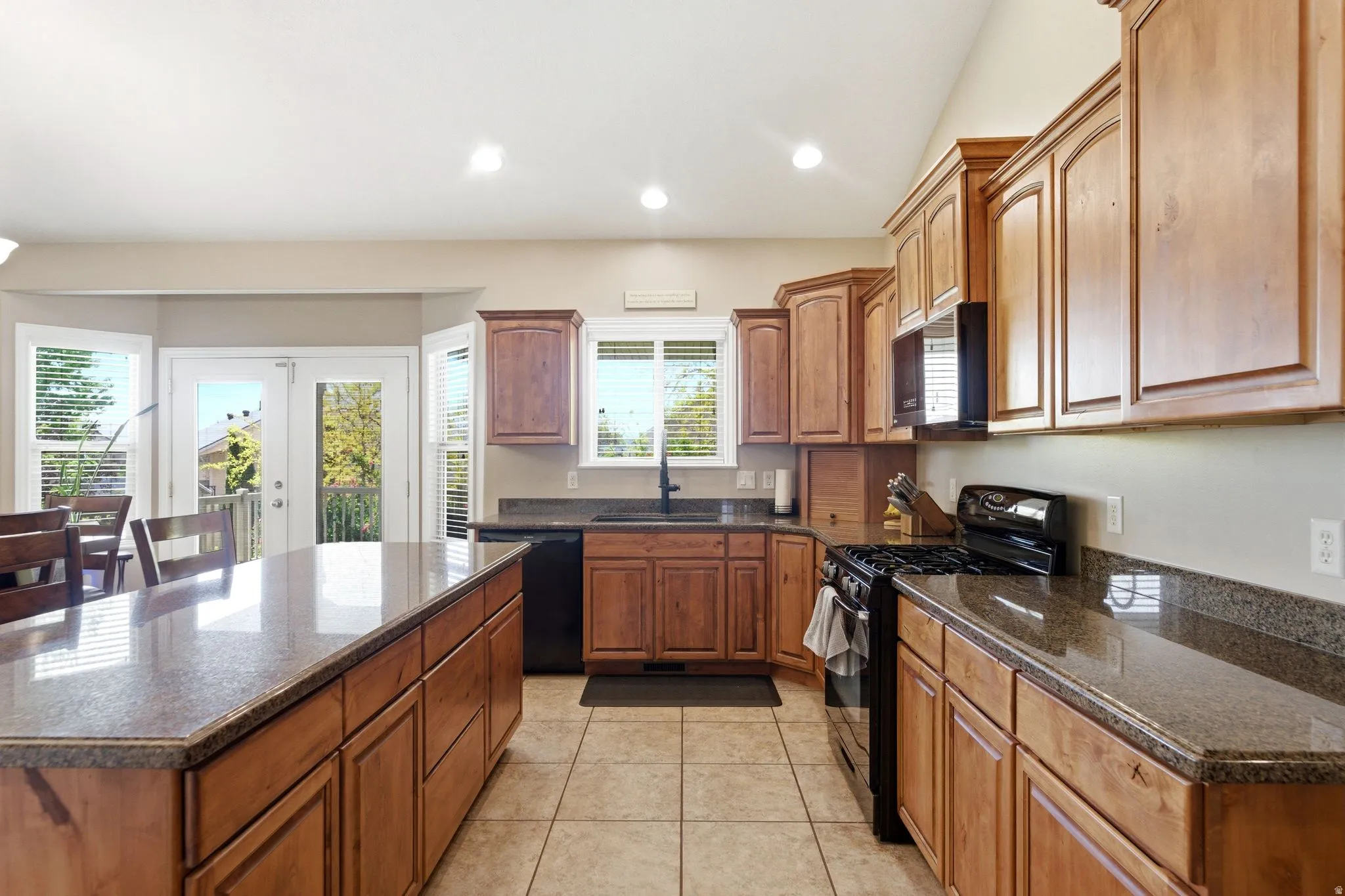 Kitchen featuring wood-finish cabinetry, granite countertops, and tile flooring