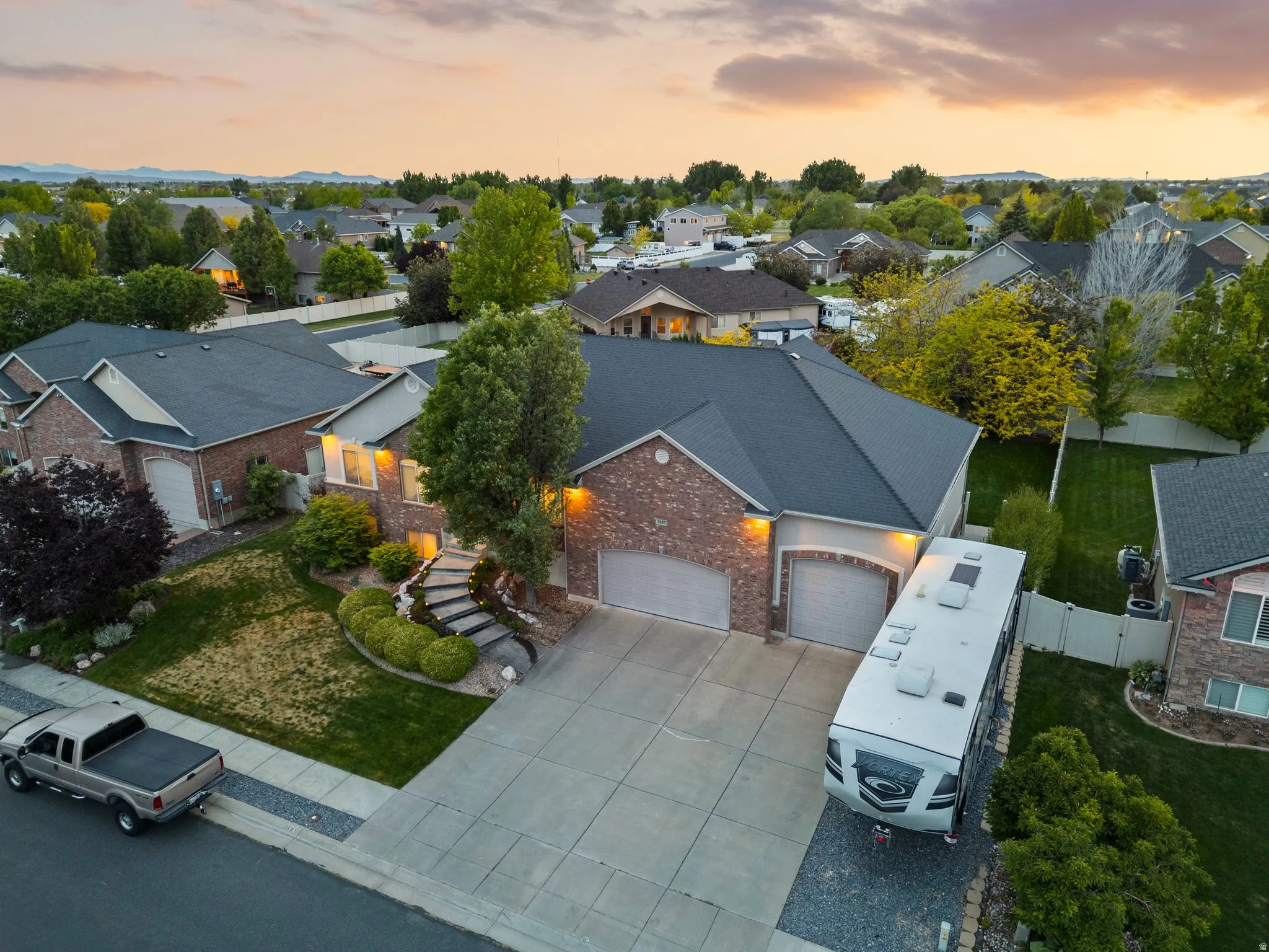 Brick and siding exterior featuring a multi-car driveway and an additional gravel parking area