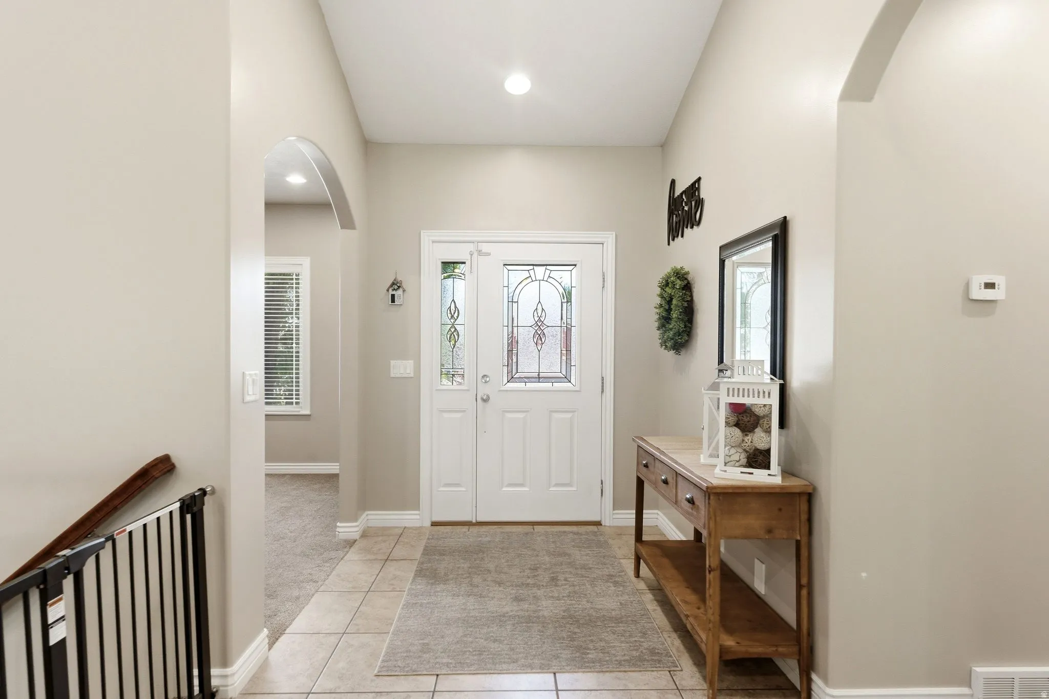Entryway featuring a white door with decorative glass inserts, recessed lighting, and tile flooring
