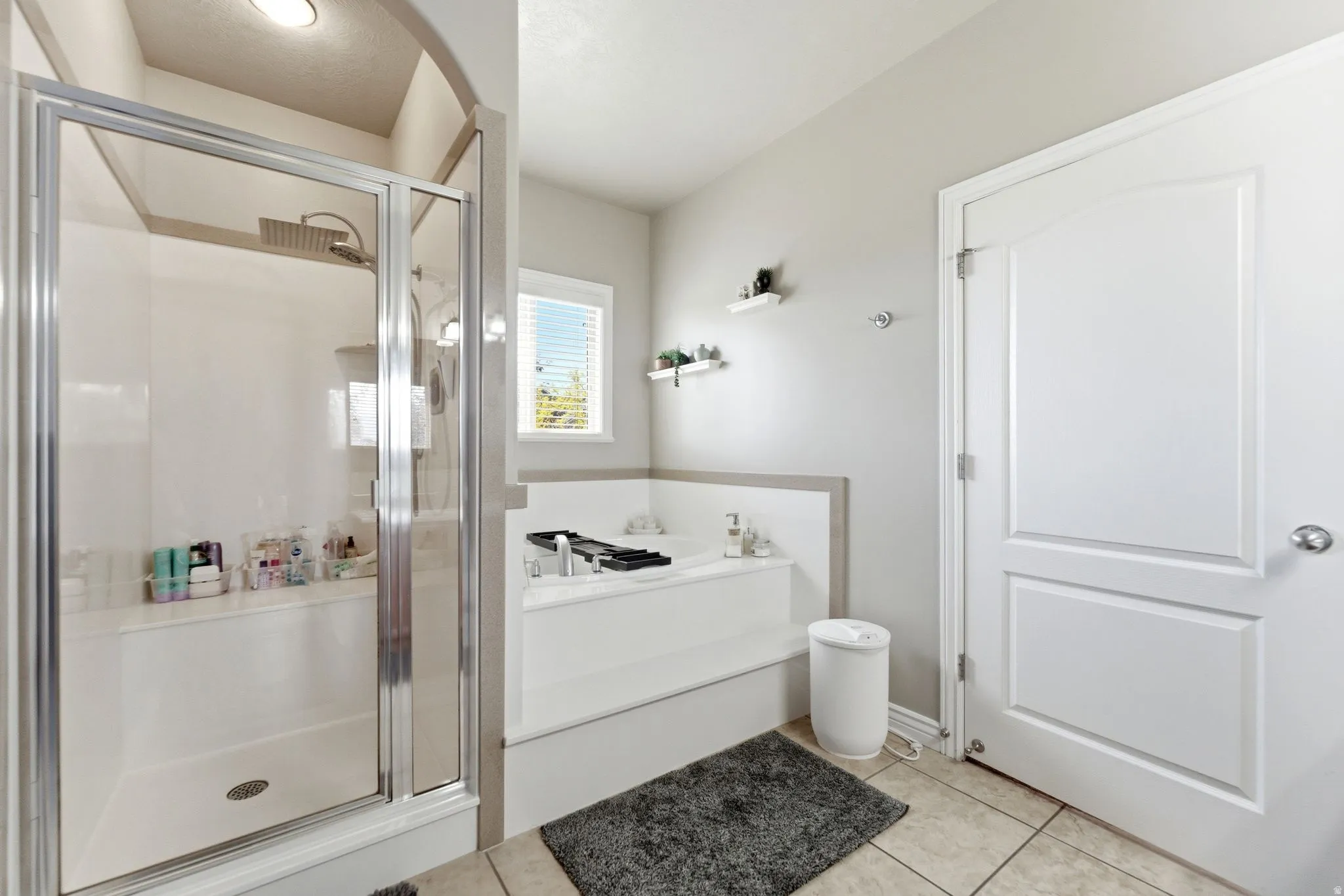 Glass-enclosed shower with integrated bench seating and a rain shower head