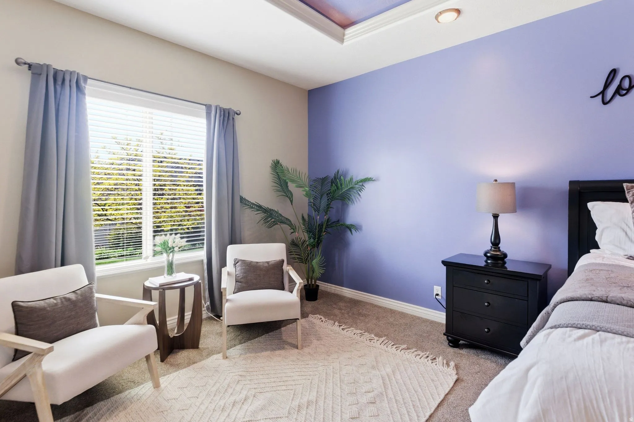 Spacious room featuring a large window with blinds, tray ceiling with recessed lighting, and soft carpet flooring