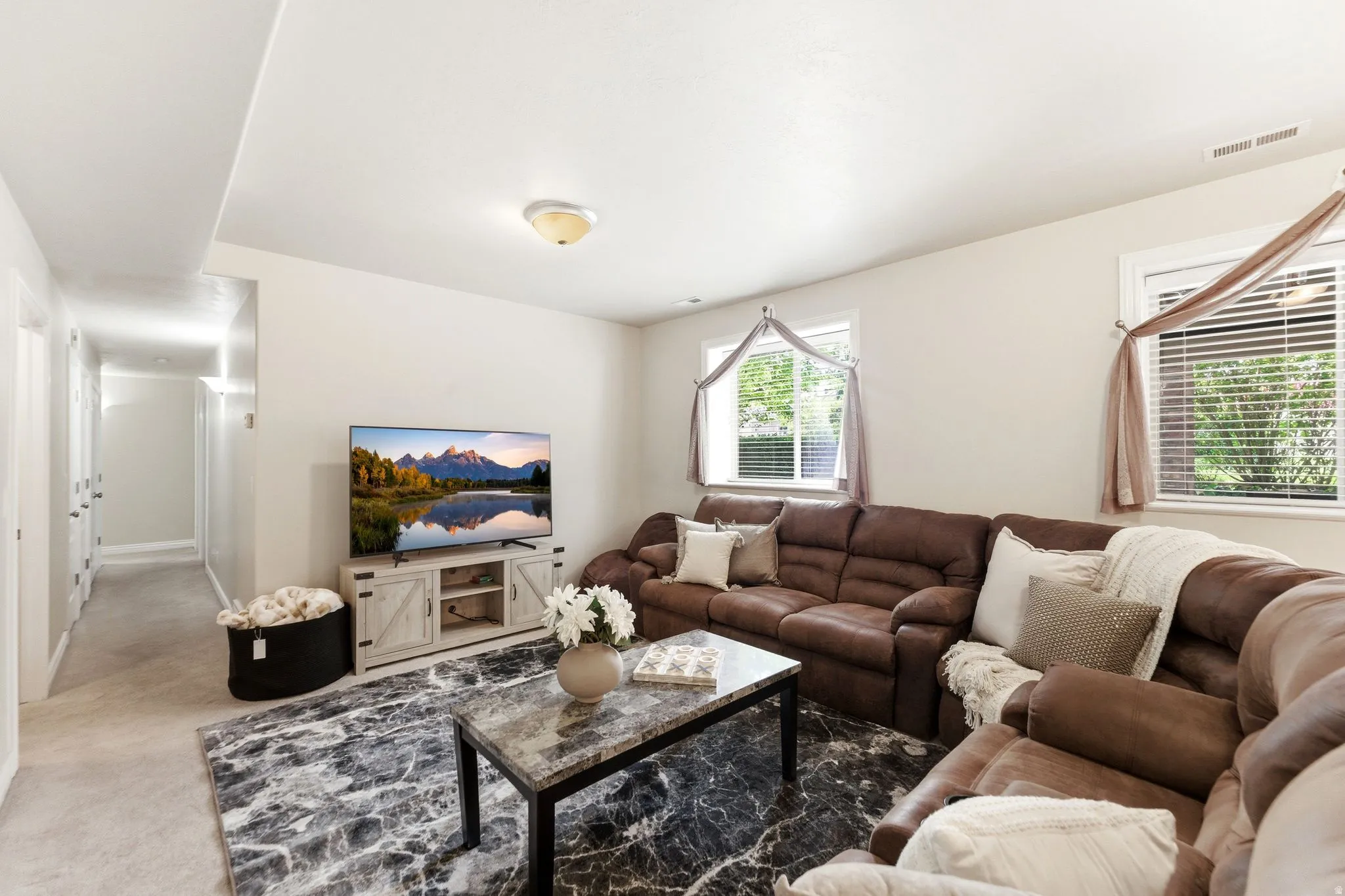 Spacious entertainment area featuring light-colored walls and recessed lighting