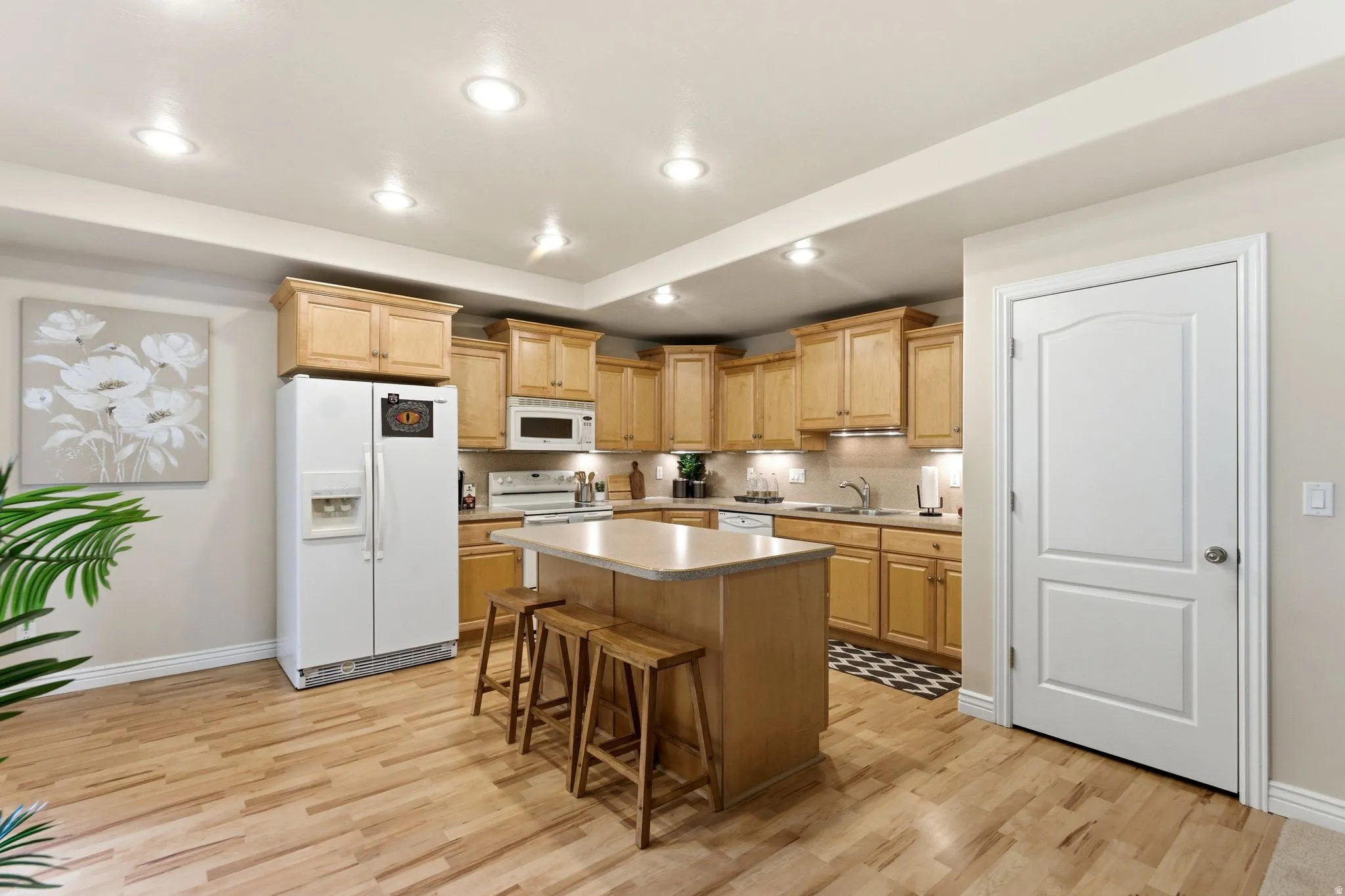 Kitchen featuring wood-finish flooring, recessed lighting, and light-toned cabinetry