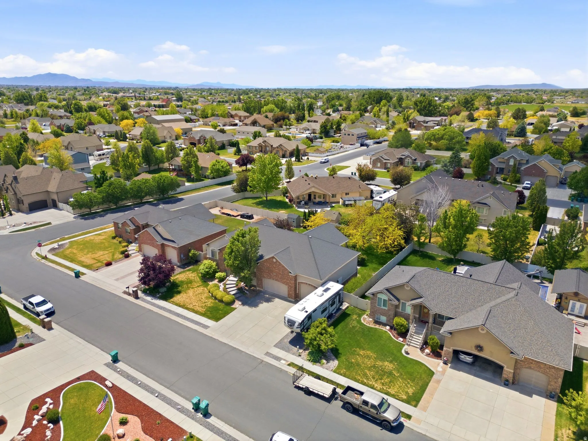 Residential neighborhood featuring established homes with diverse architectural styles, mature landscaping, and mountain backdrops