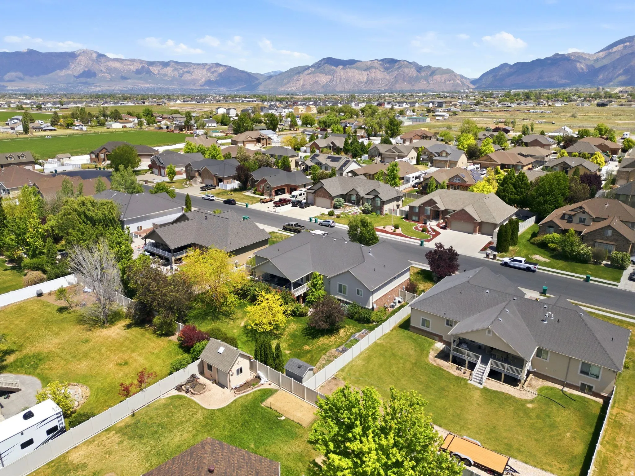Residential neighborhood featuring single-family homes with pitched roofs, mature trees, and landscaping