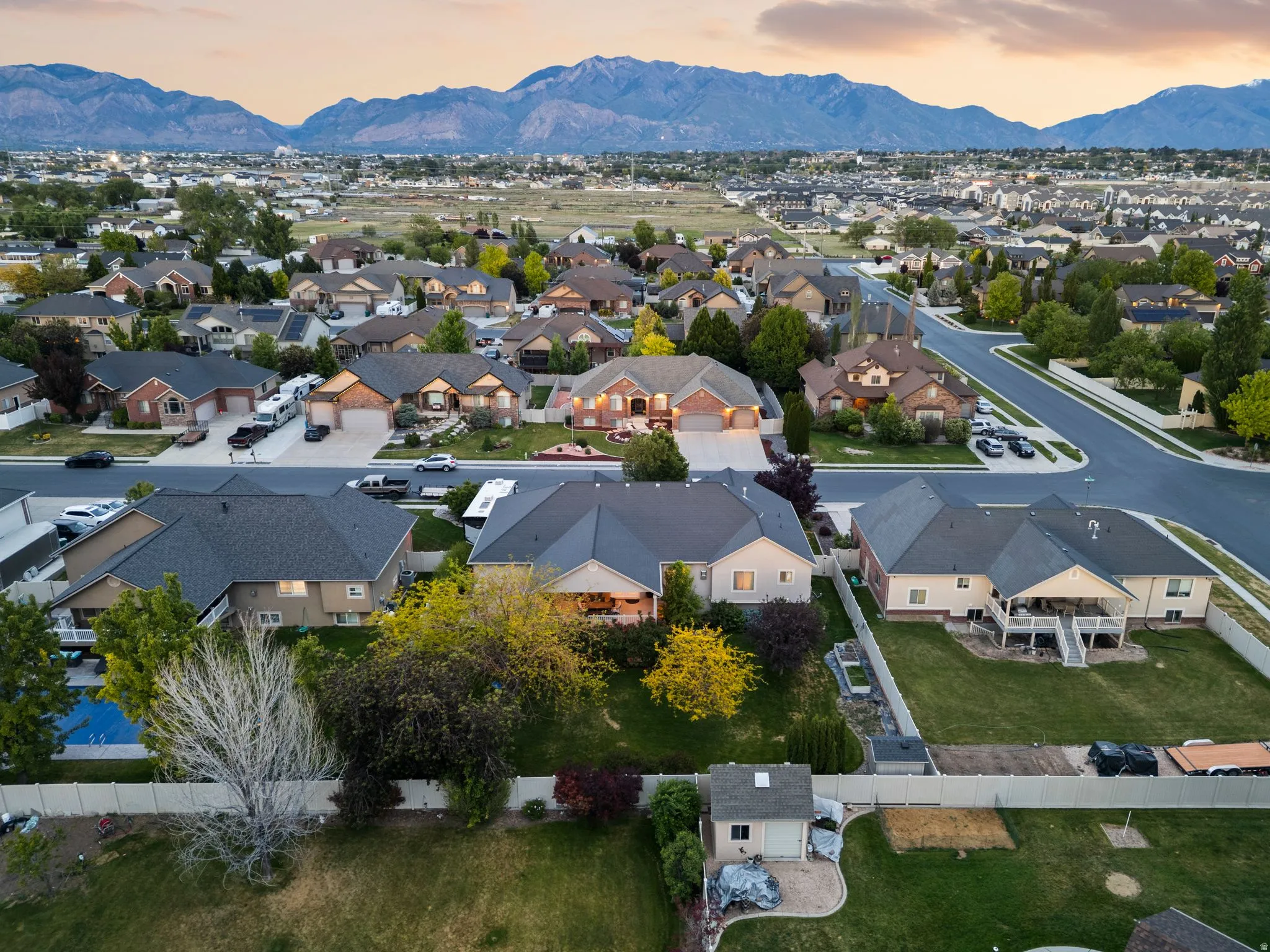 Residential neighborhood featuring varied single-family homes, mature landscaping, and mountain backdrops