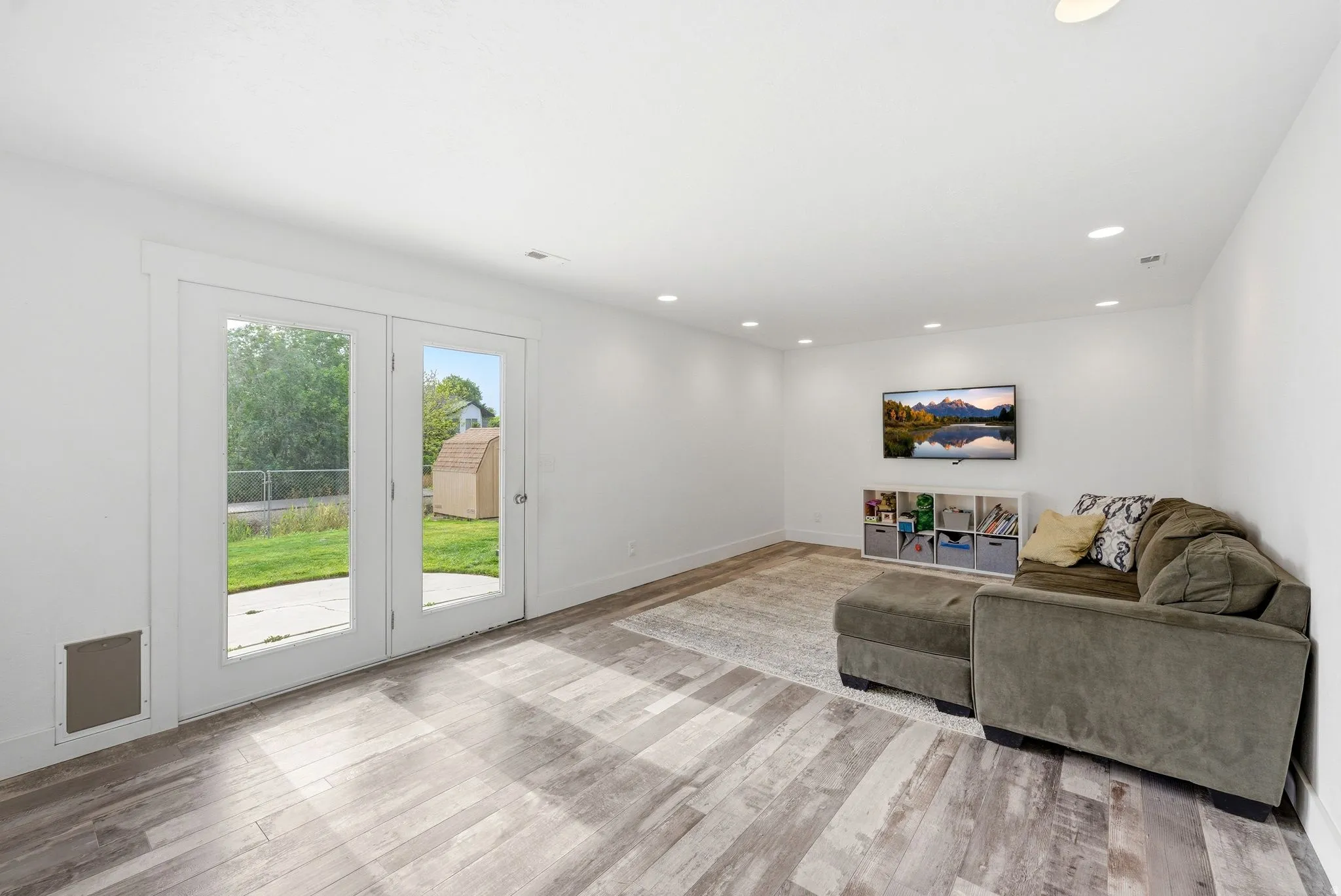 Spacious room with wood-finish flooring and recessed lighting