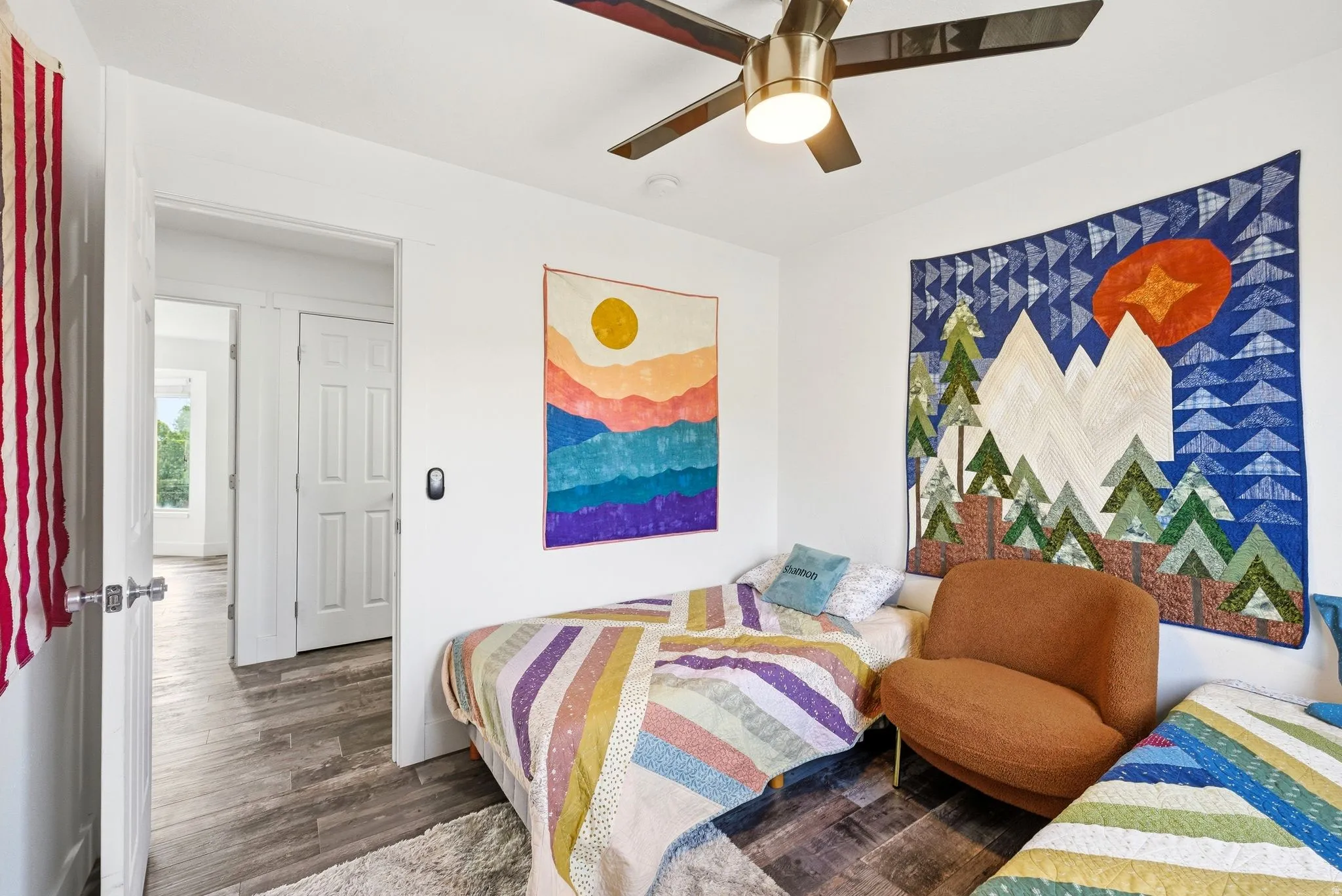 Interior room featuring white walls, wood-finish flooring, and a ceiling fan with integrated lighting