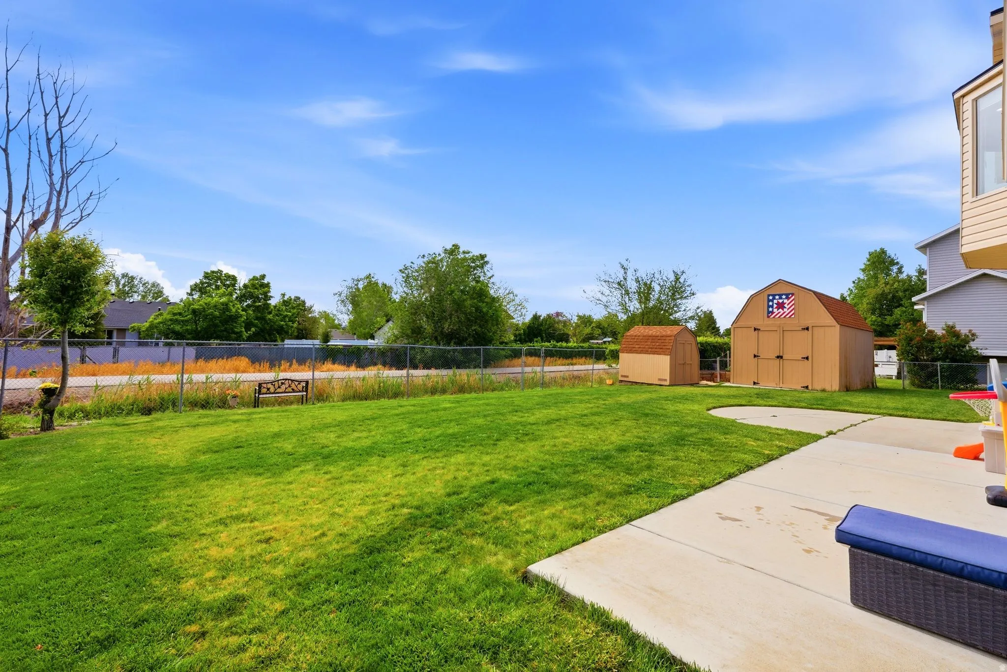Expansive green lawn with a concrete patio