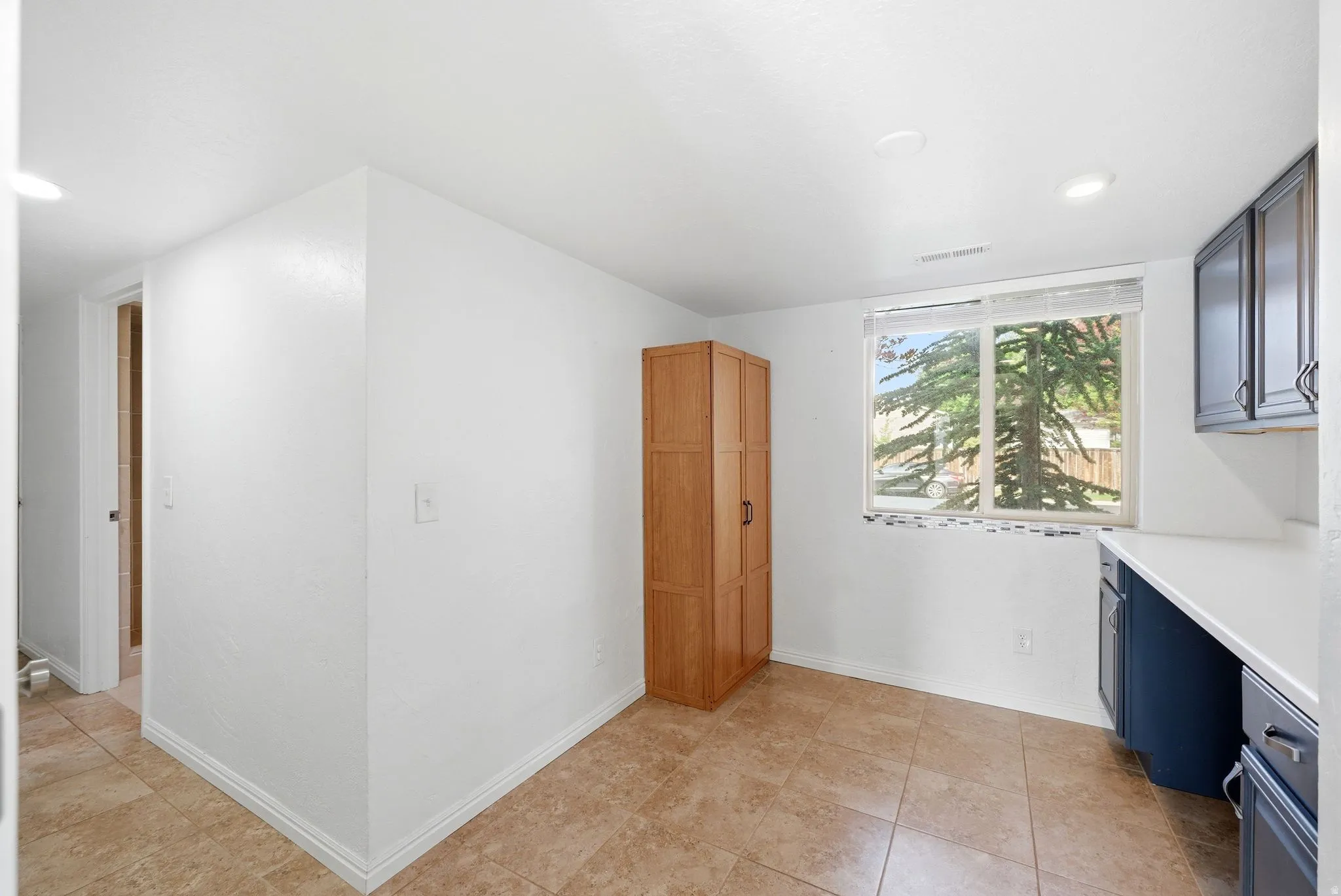 White walls with recessed lighting and tile flooring