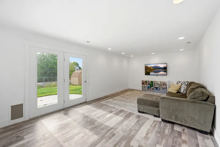 Spacious room with wood-finish flooring and recessed lighting