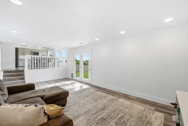 Open-concept living space featuring wood-finish flooring, recessed lighting, and white walls