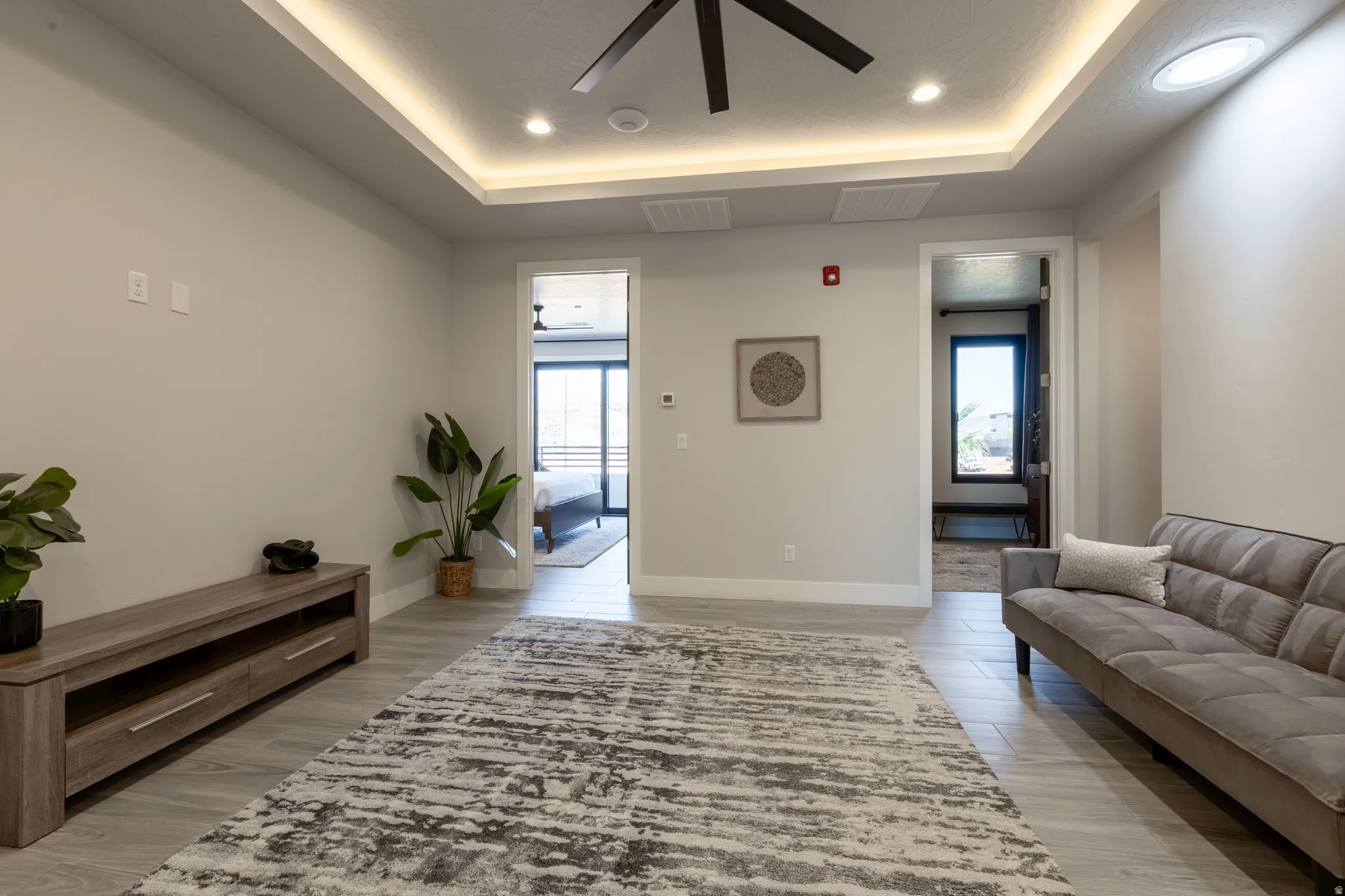 Spacious room featuring light-toned walls, recessed lighting, and a ceiling fan