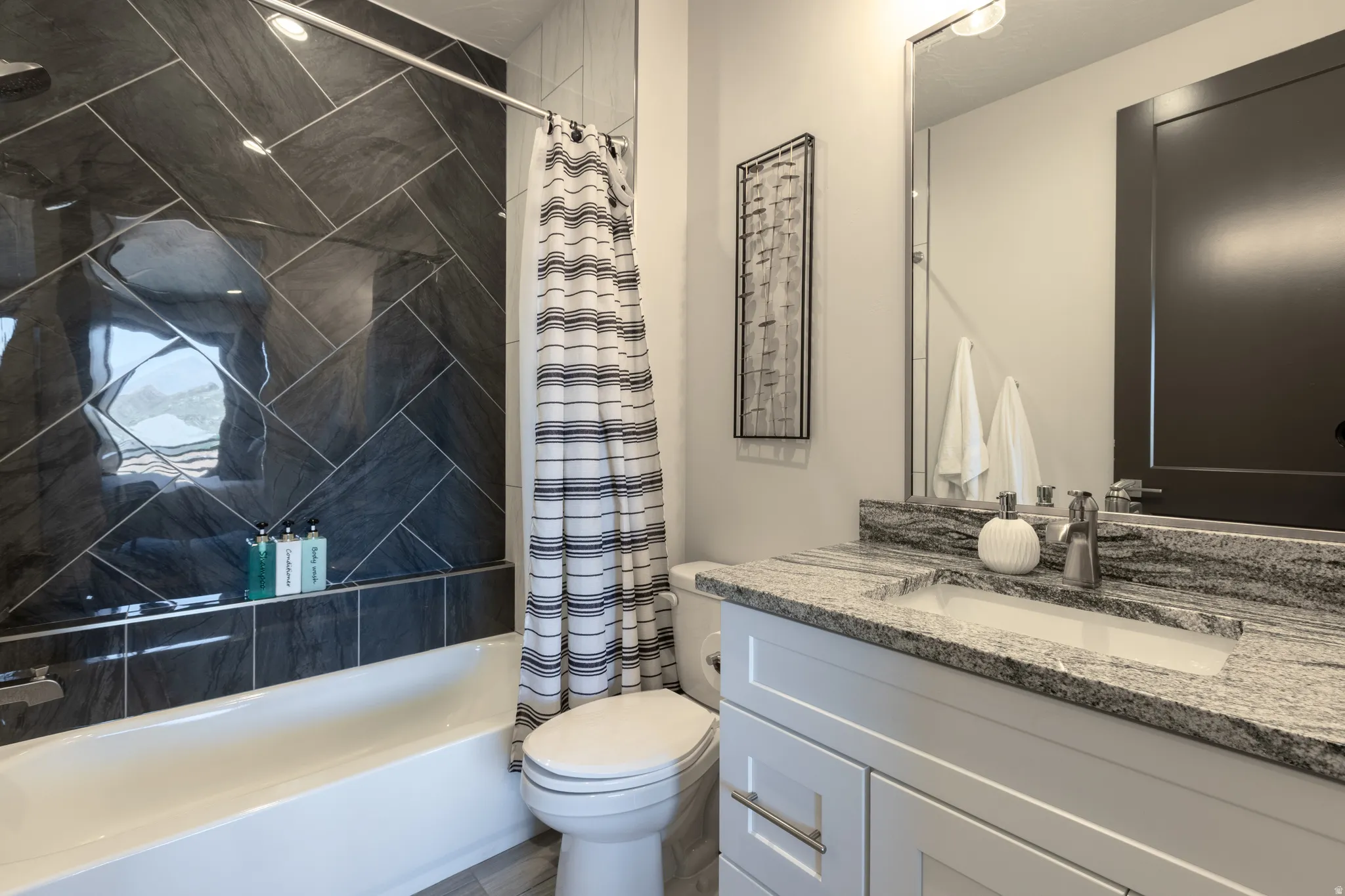 Bathroom featuring a white vanity with a light-toned countertop, an undermount sink, and a framed mirror