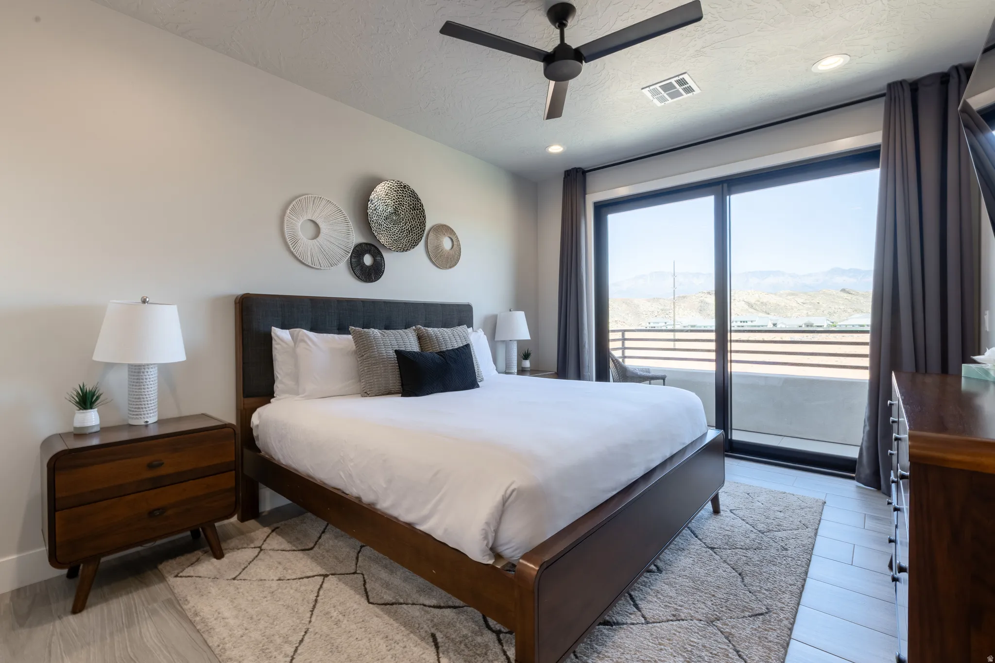 Spacious room featuring light-toned walls and wood-finish flooring
