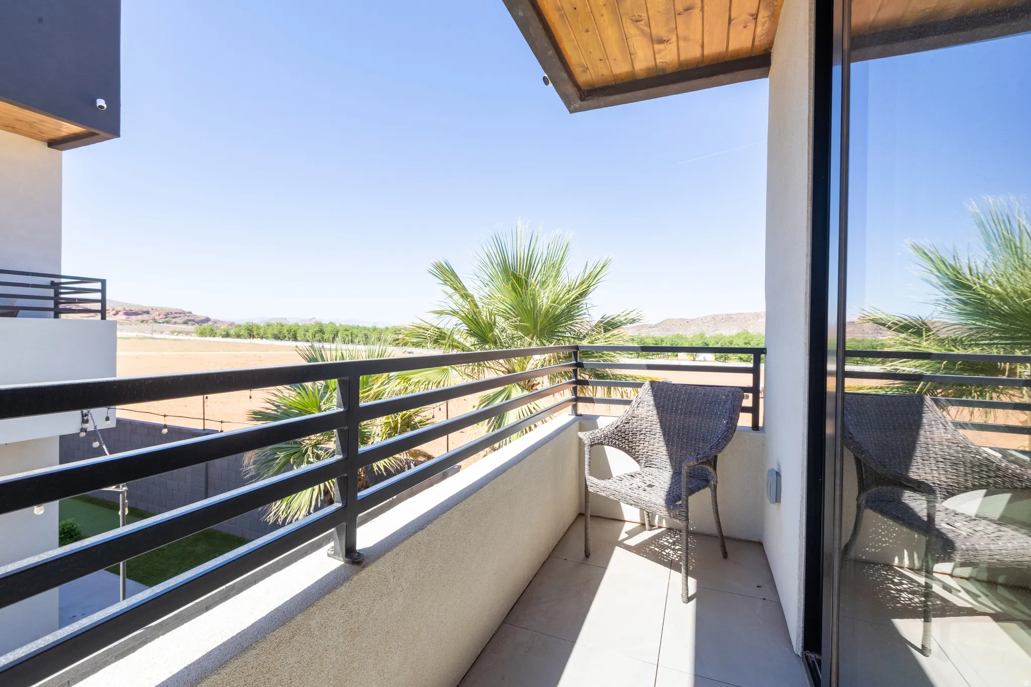 Private balcony with metal railings and a wood-finish ceiling accent