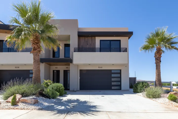 Contemporary stucco exterior featuring a flat roofline and dark trim accents
