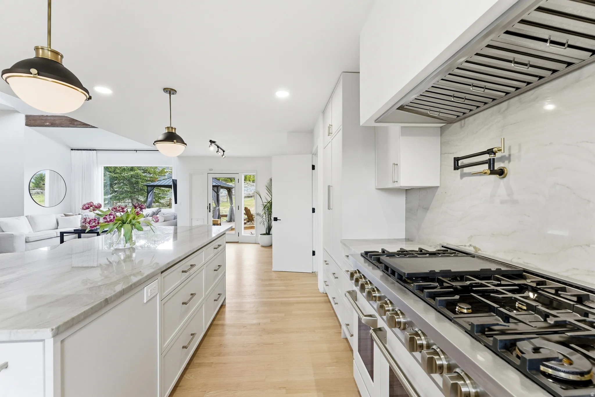 Gourmet kitchen featuring a stainless steel range with griddle, pot filler, and a custom range hood