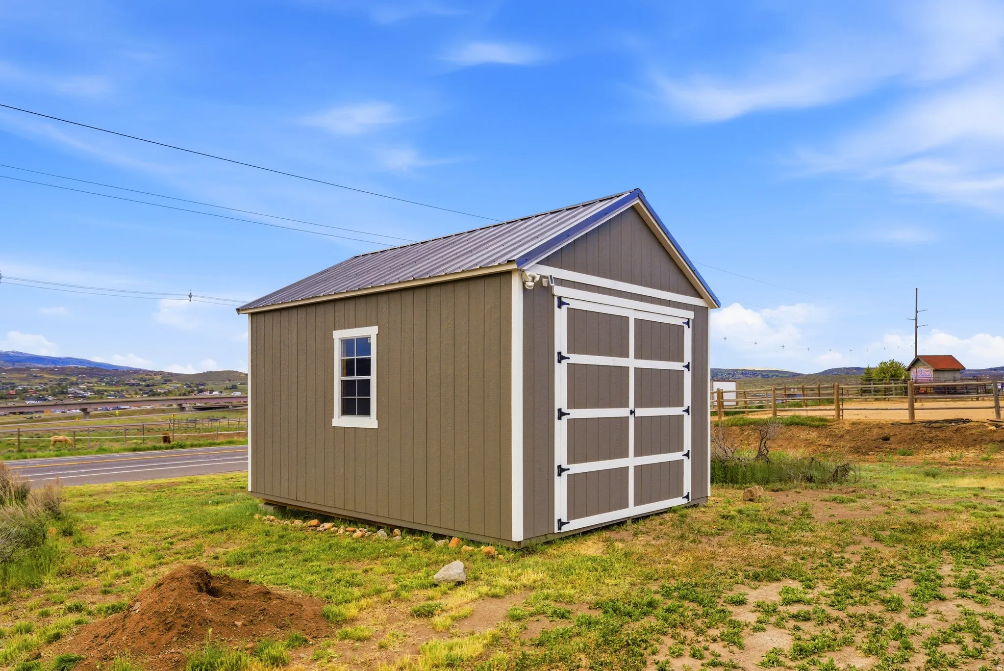 Freestanding shed featuring board and batten siding, a metal roof, and a single window