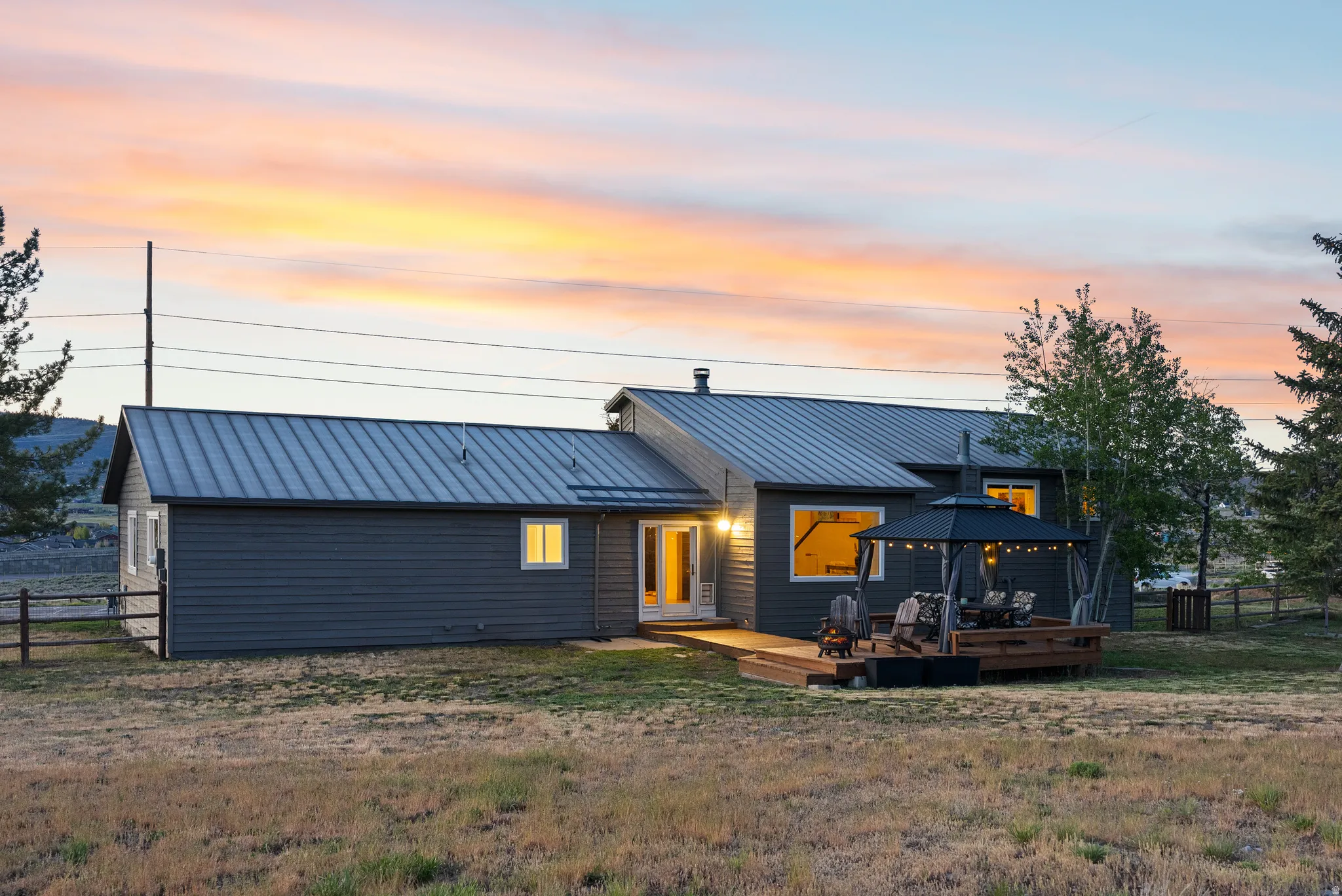 Contemporary exterior with dark gray siding and a standing seam metal roof