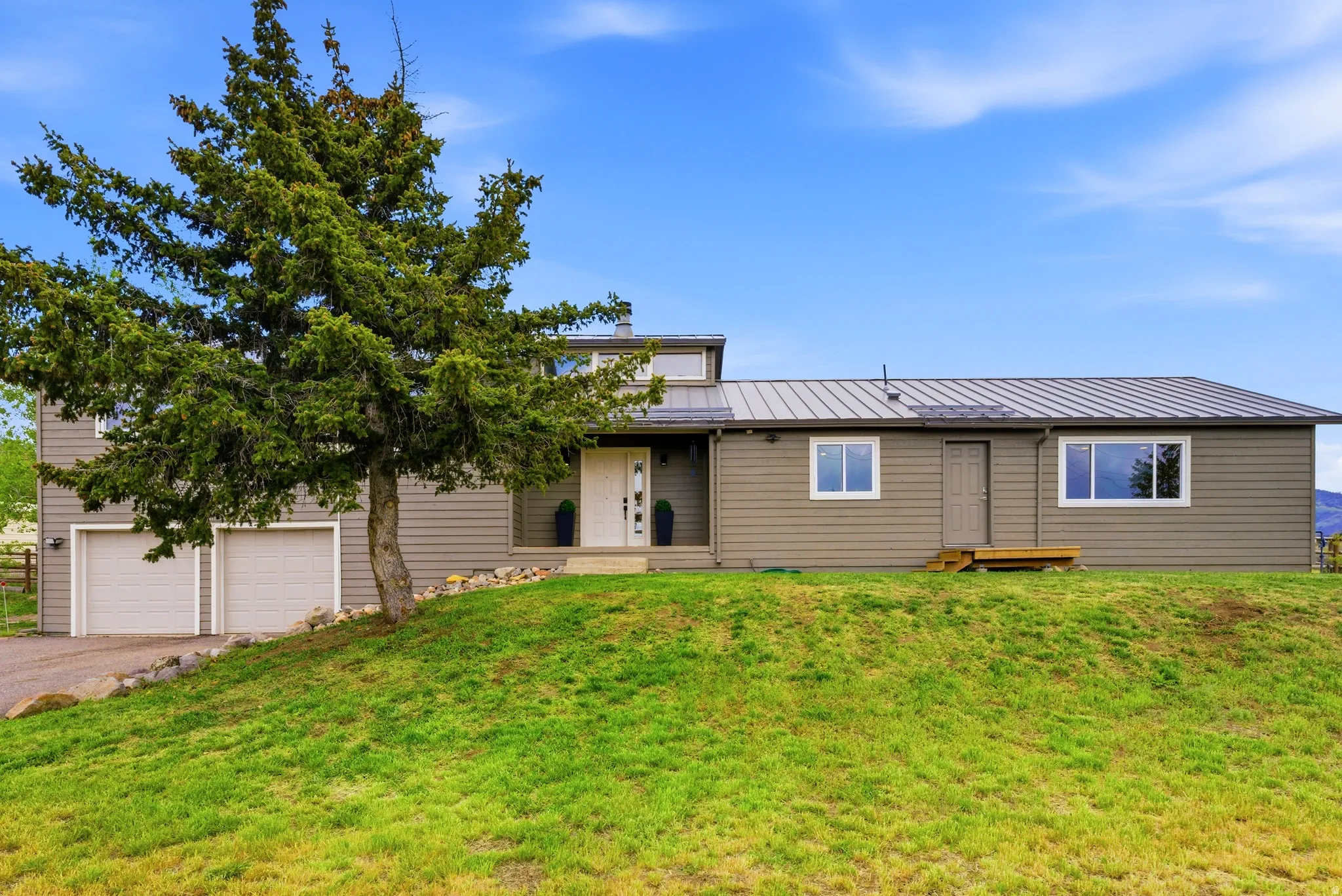 Split-level home featuring horizontal siding and a metal roof