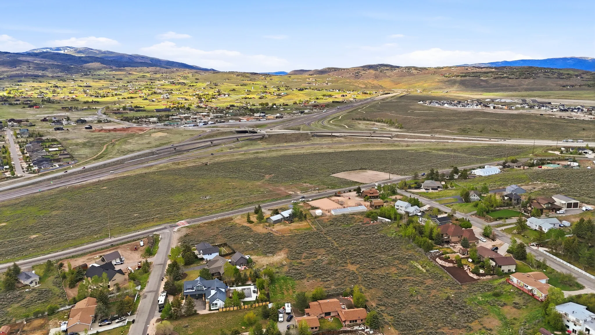 Expansive aerial view showcasing residential properties amidst natural terrain