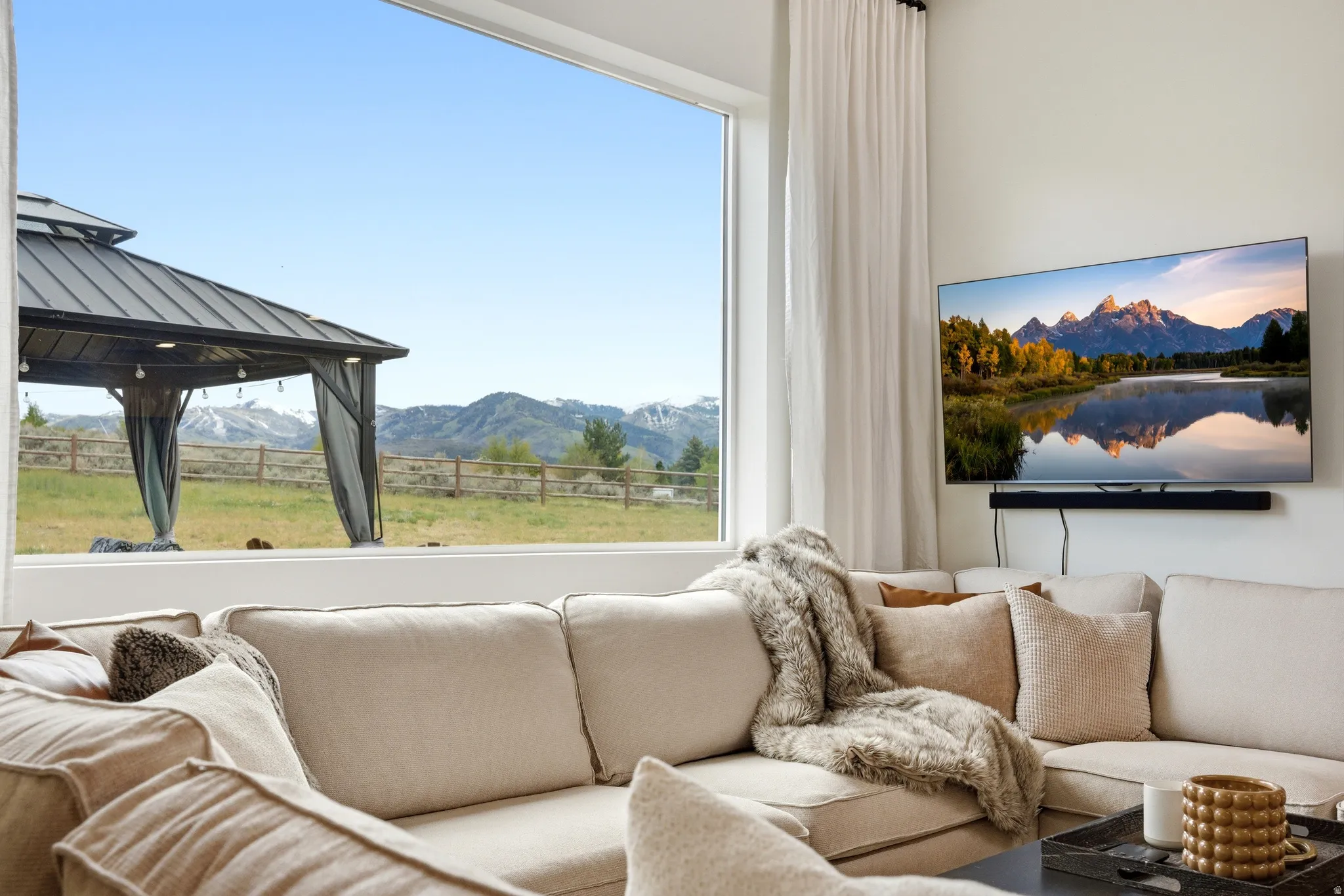 Panoramic window with a mountain backdrop, featuring a gazebo and expansive outdoor space