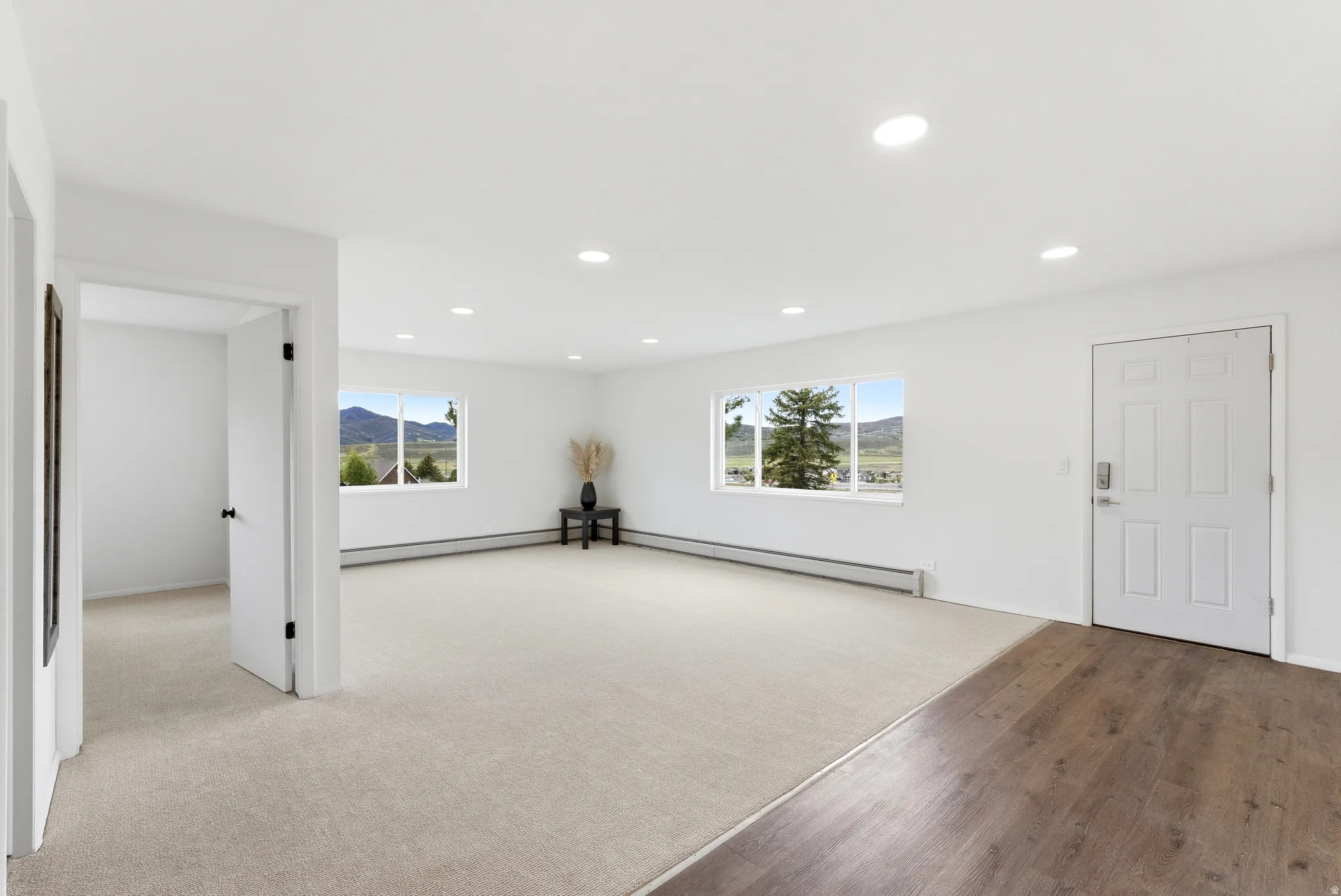Spacious interior with neutral carpeting and wood-finish flooring