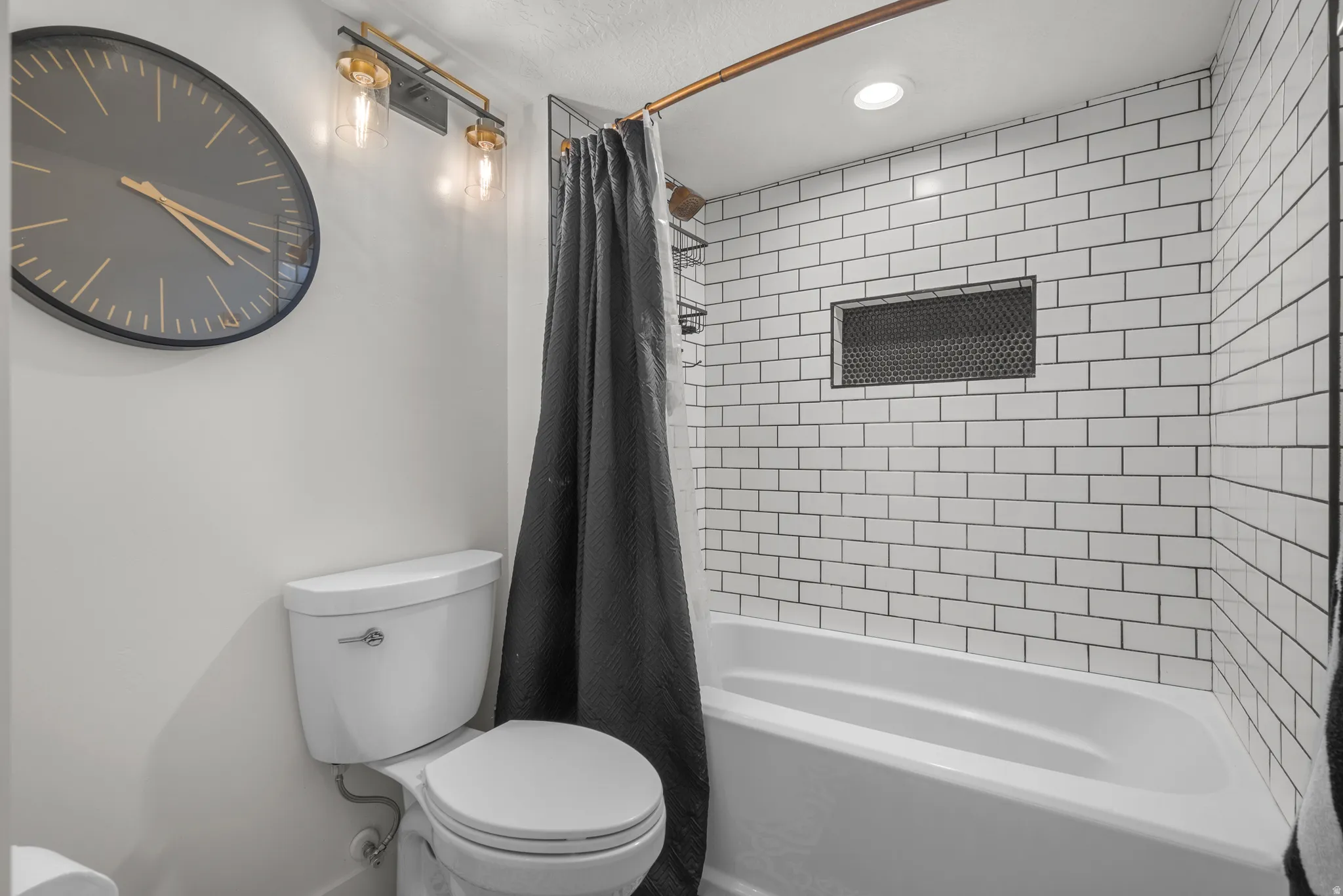 Bathroom featuring a white subway tile tub surround with a recessed niche