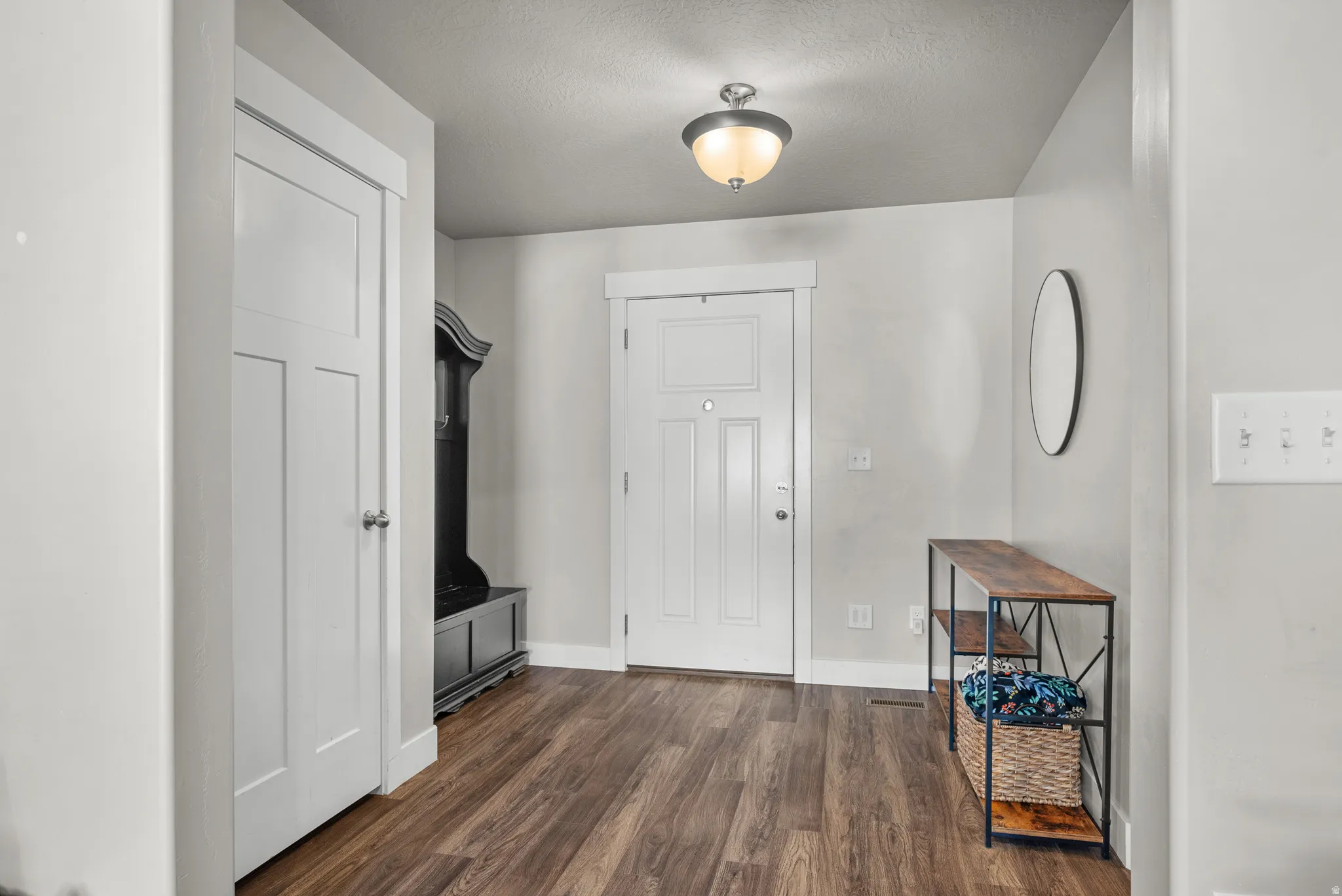 Entryway featuring wood-finish flooring, white paneled doors, and a semi-flush mount ceiling light