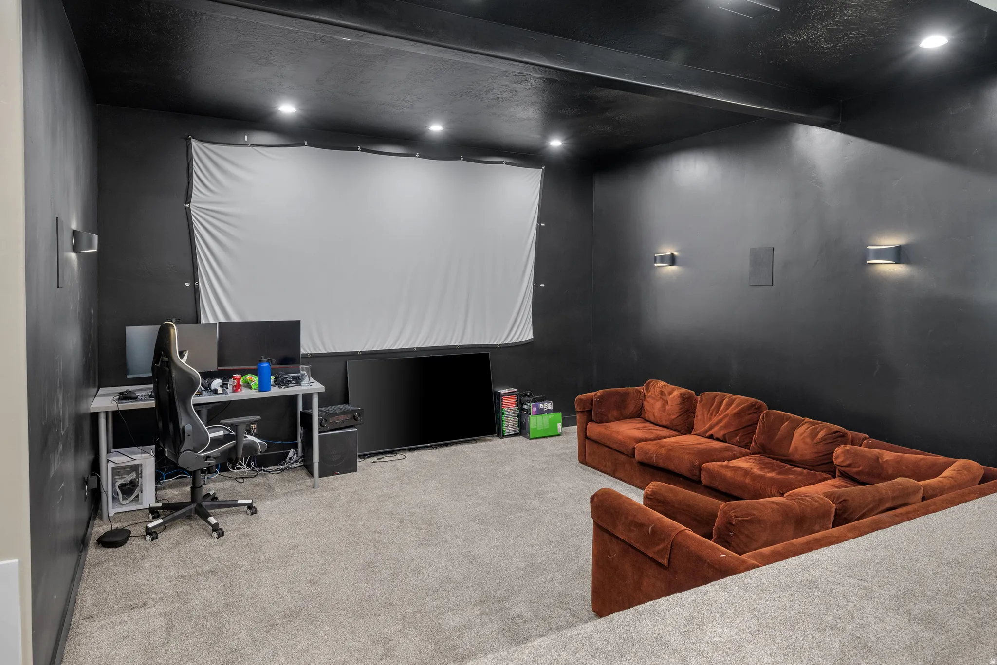 Dedicated media room with dark walls and ceiling for optimal viewing