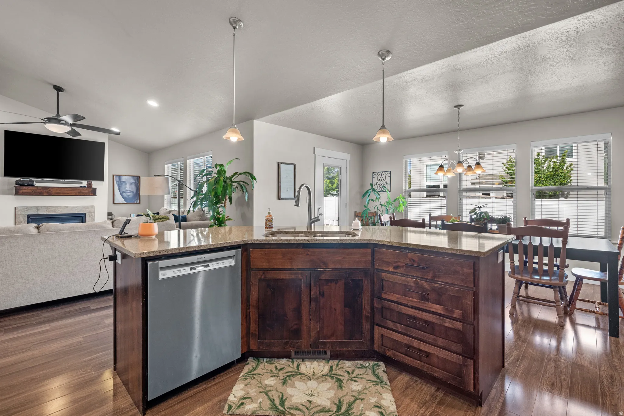 Spacious kitchen island with a built-in stainless steel dishwasher, an undermount sink, and granite countertops