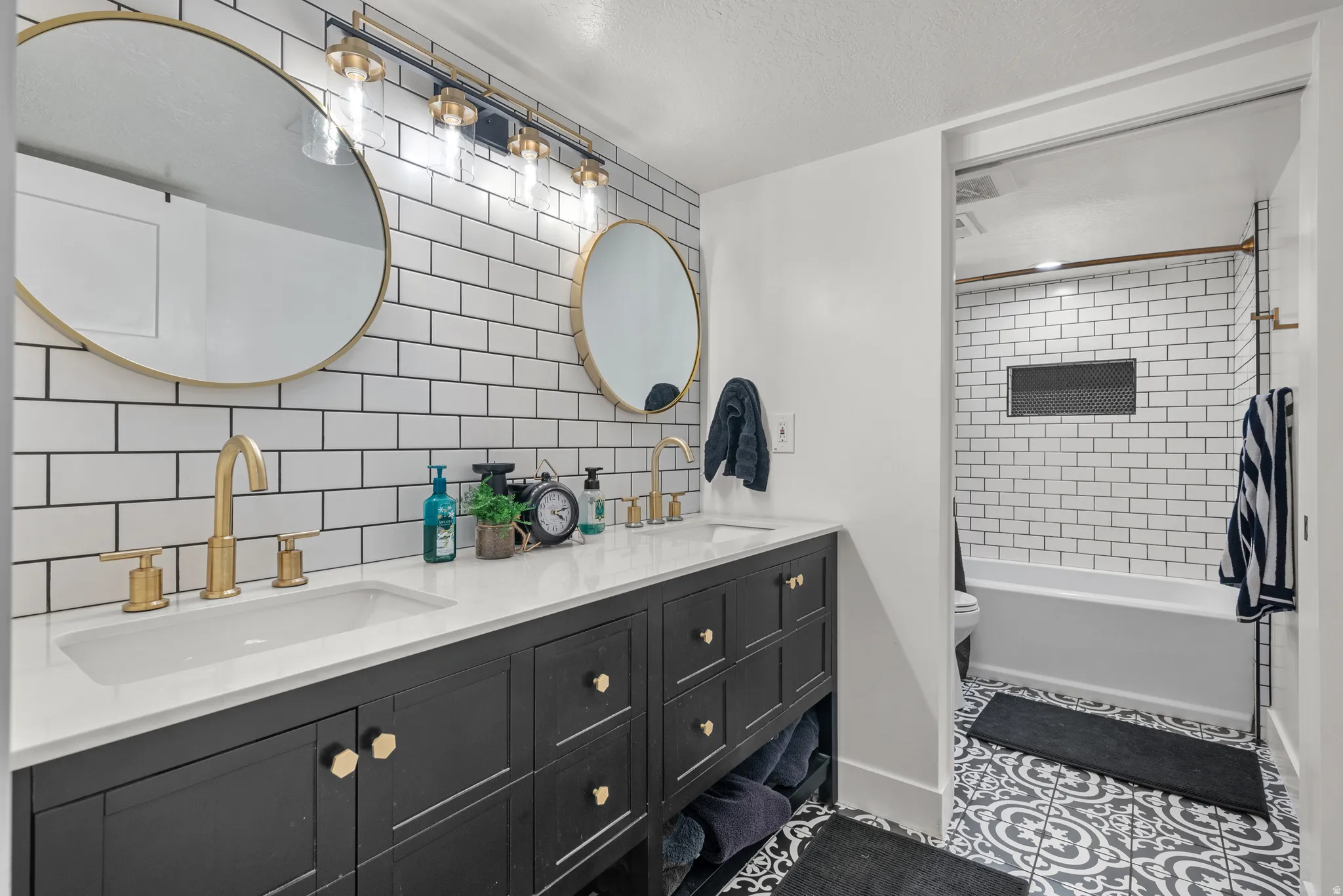Dual vanity with a white countertop and gold-toned fixtures