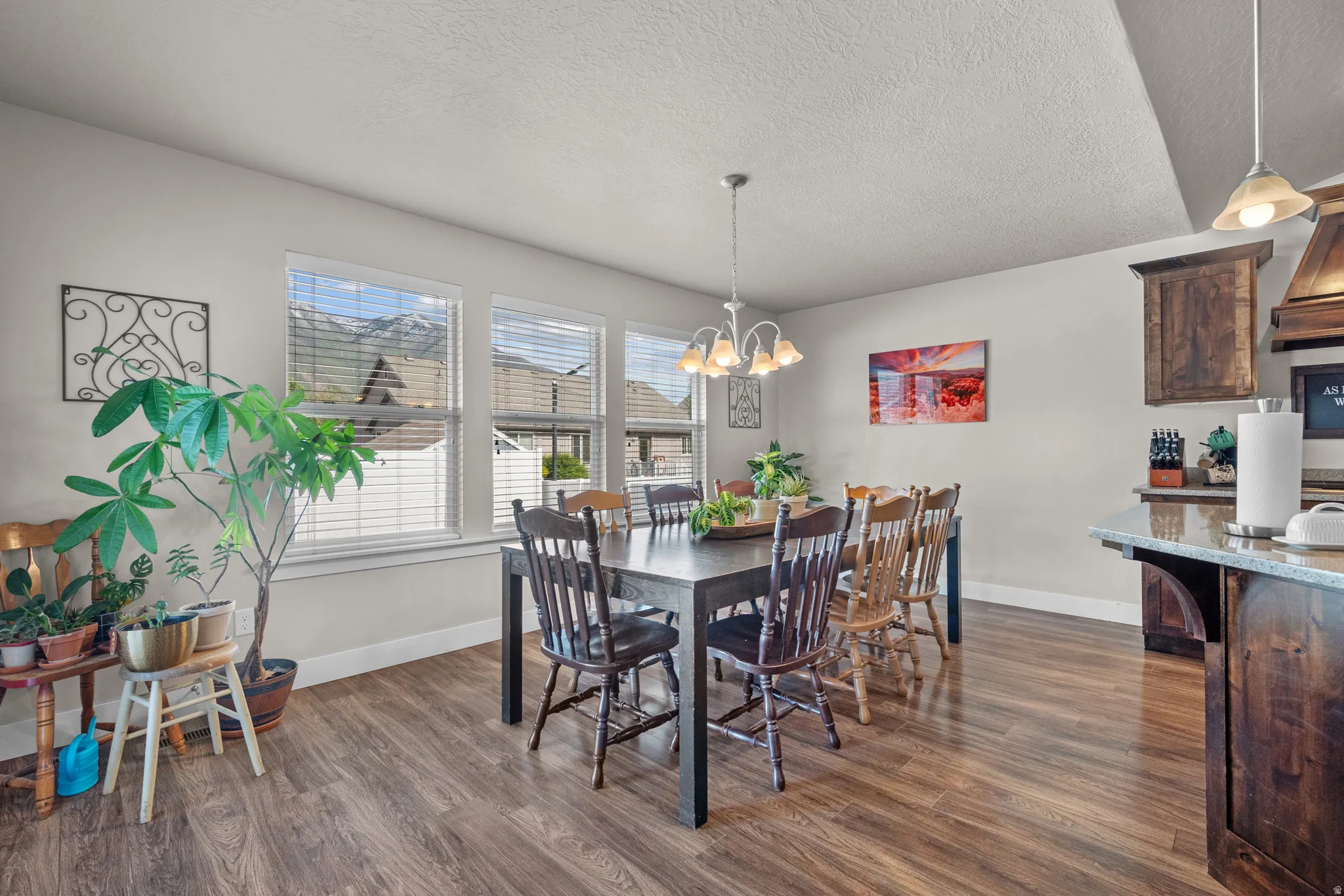 Dining area featuring wood-finish flooring and three windows with mountain scenery