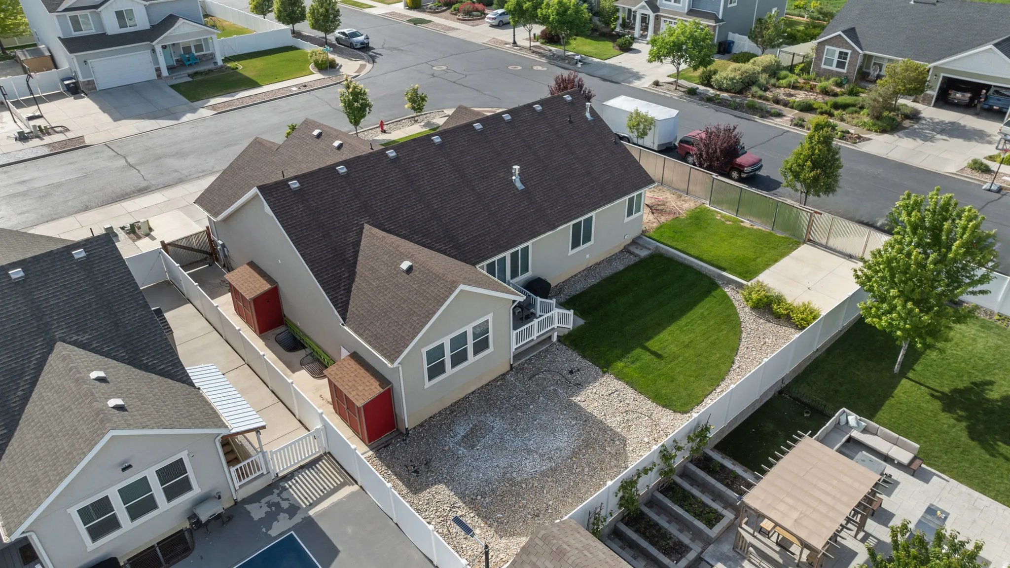 Aerial perspective showcasing a light-colored exterior with a dark shingle roof