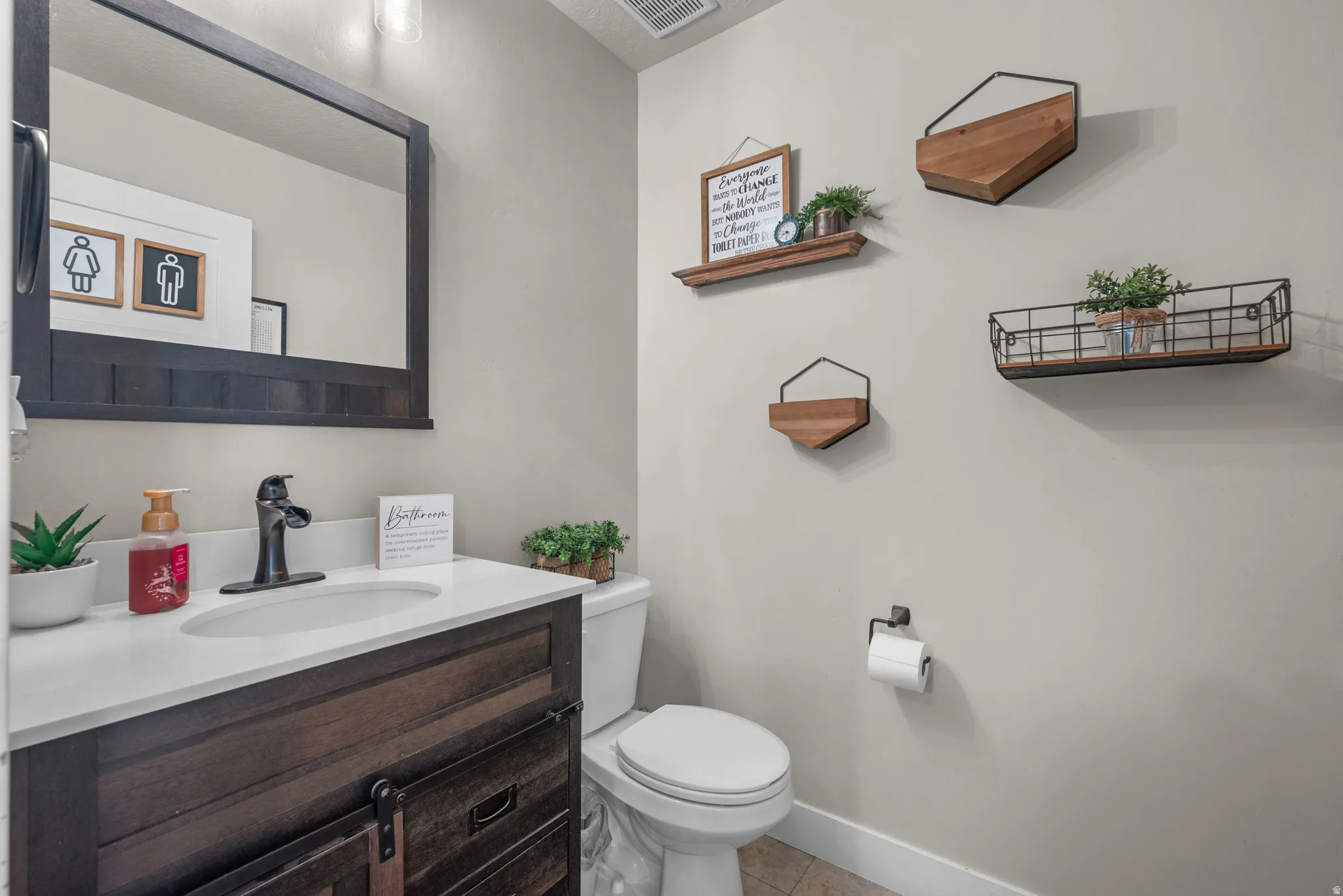 Bathroom featuring a single vanity with a dark wood-finish cabinet and a white countertop