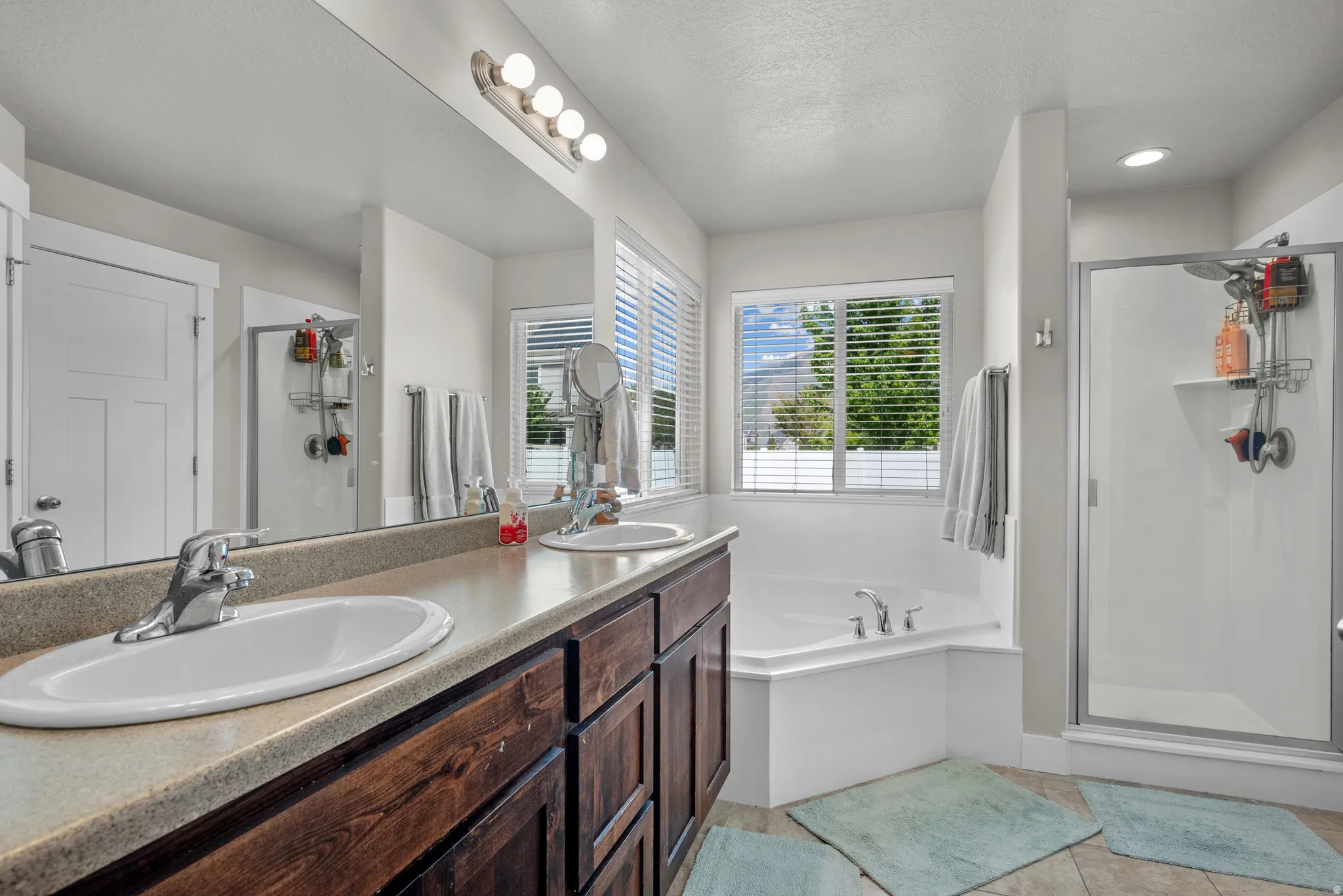 Double vanity with integrated sinks and dark wood-finish cabinetry