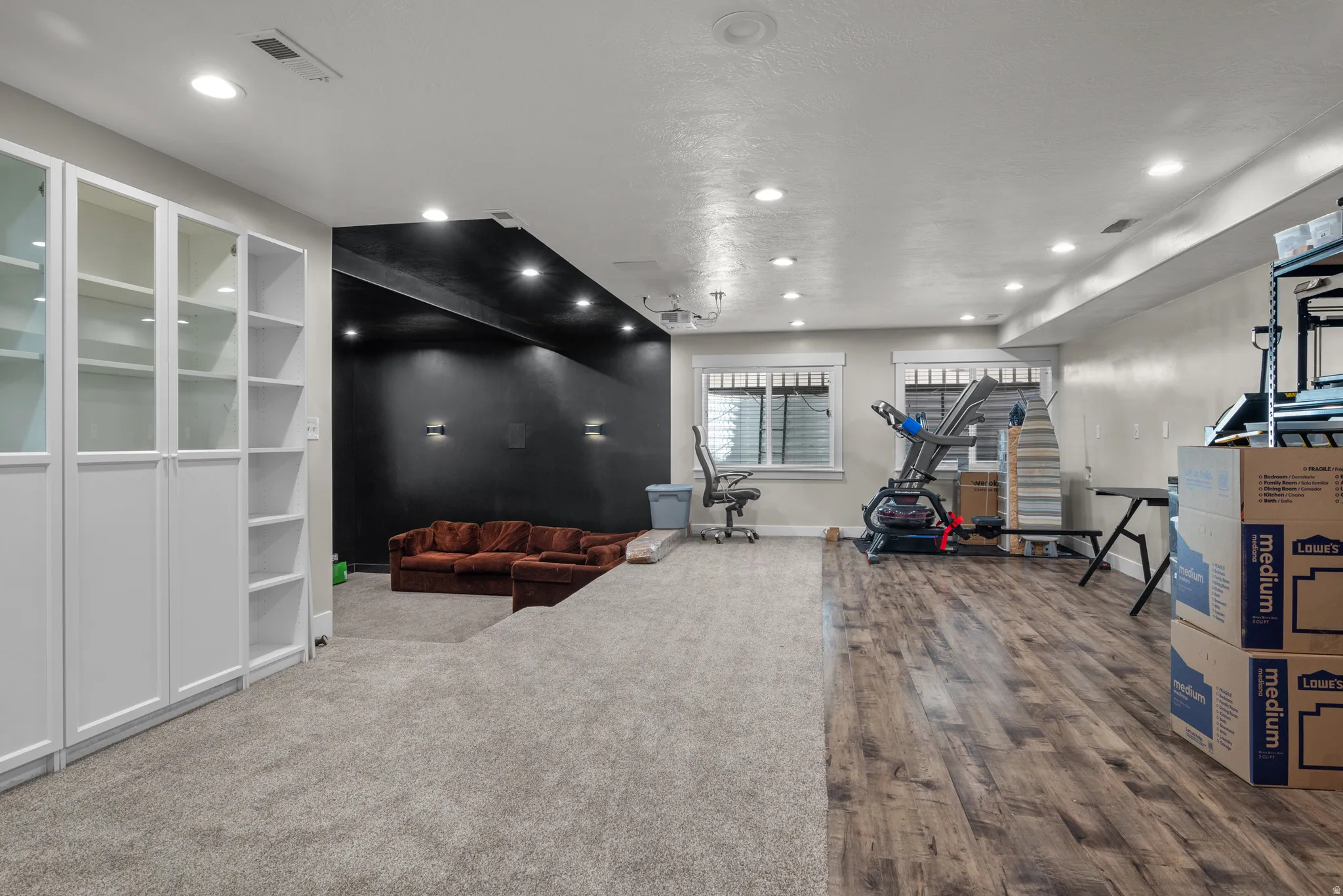 Spacious interior featuring a combination of wood-finish flooring and plush carpeting