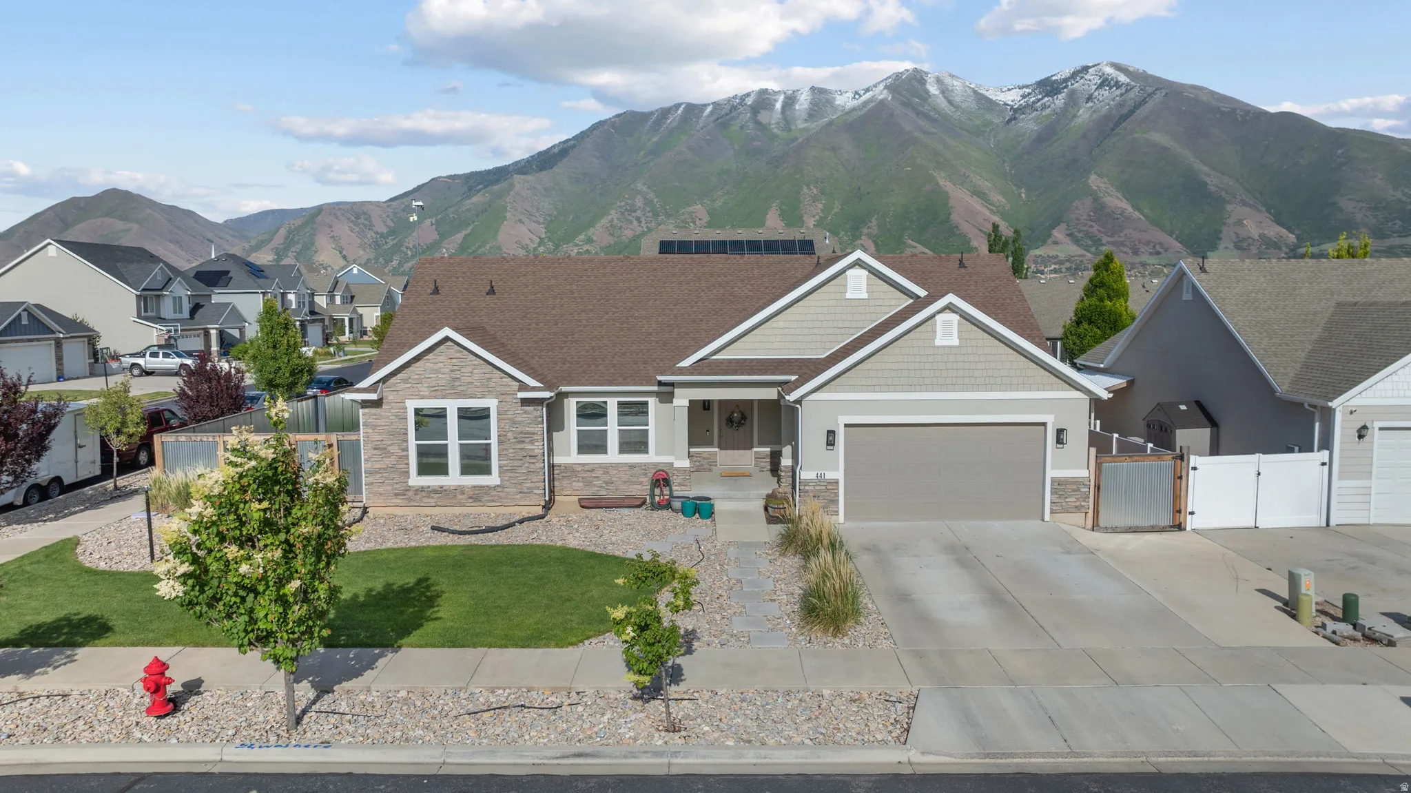 Modern rambler residence with a stone and siding facade, featuring an attached two-car garage