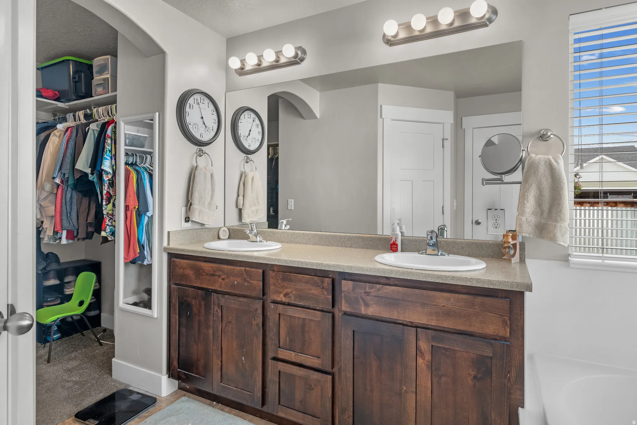 Dual vanity with rich wood-finish cabinetry and light-toned countertops