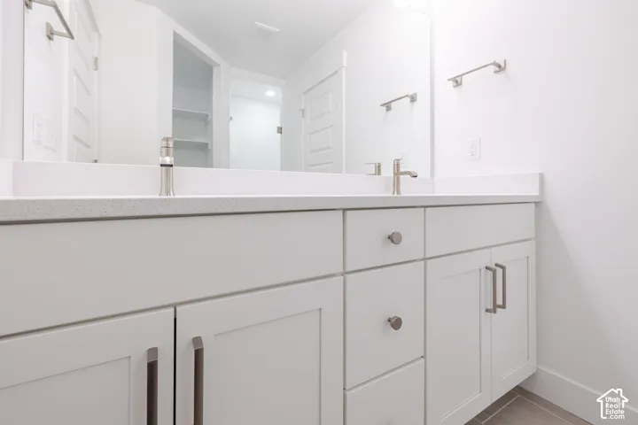 Dual vanity with white cabinetry, brushed nickel hardware, and light-toned countertops