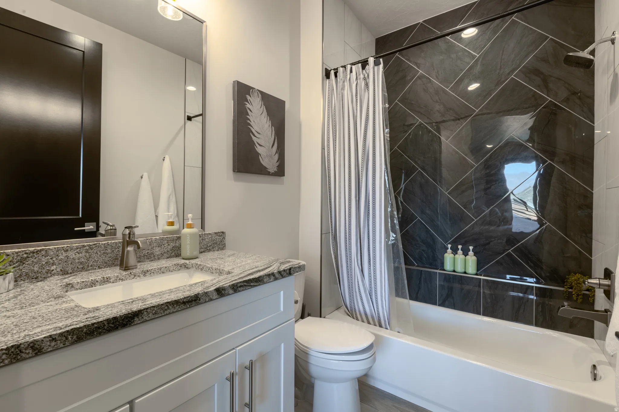 Bathroom featuring a modern vanity with a rectangular undermount sink, a granite countertop, and a brushed nickel faucet