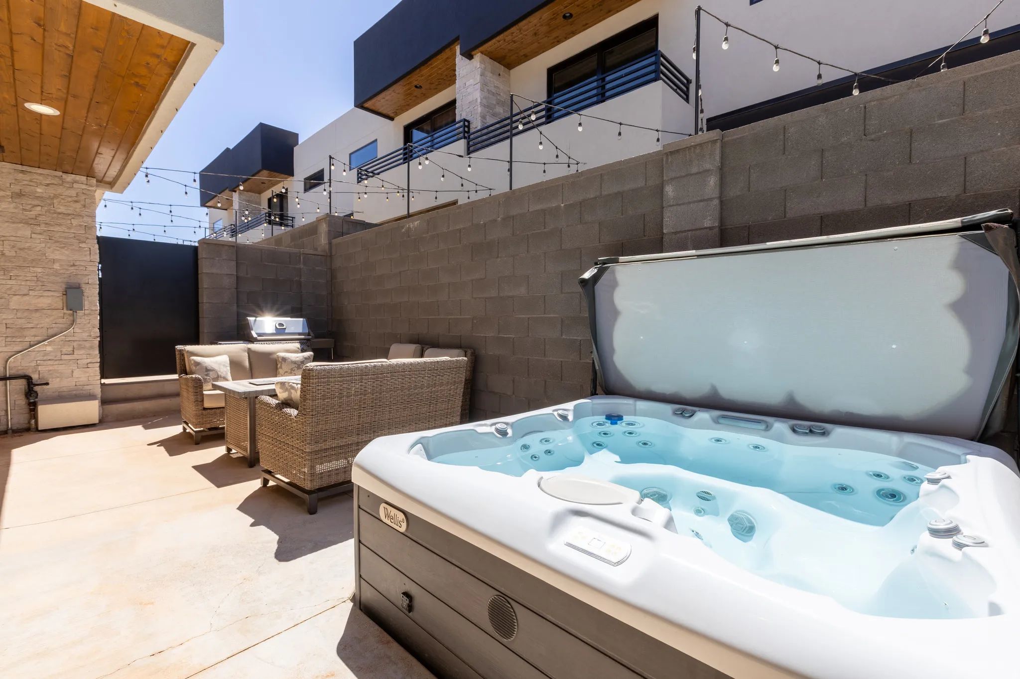 Private patio featuring an integrated hot tub and durable concrete flooring