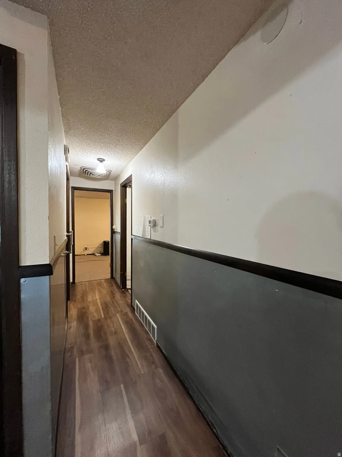 Hallway featuring wood-finish flooring, two-tone wall paint, and recessed lighting