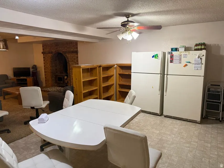 Expansive entertainment area featuring a decorative brick archway, recessed lighting, wood-finish shelving, and tiled flooring