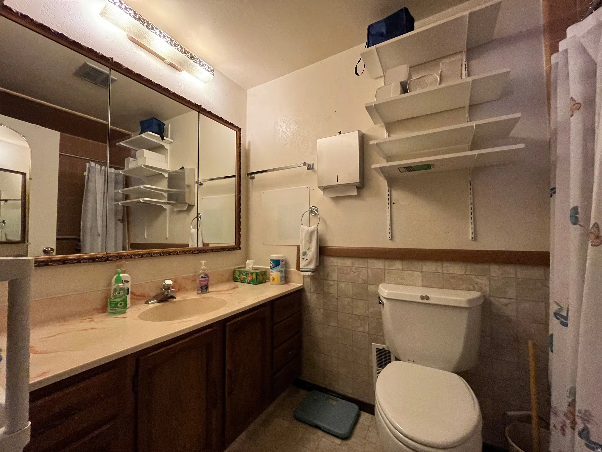 Bathroom featuring an extended vanity with an integrated sink and wood cabinetry