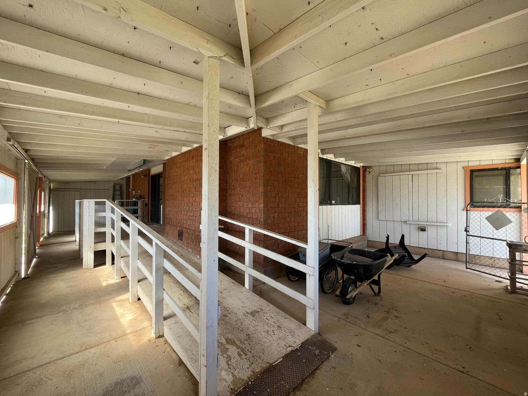 Covered exterior corridor featuring a white painted wood ceiling and posts