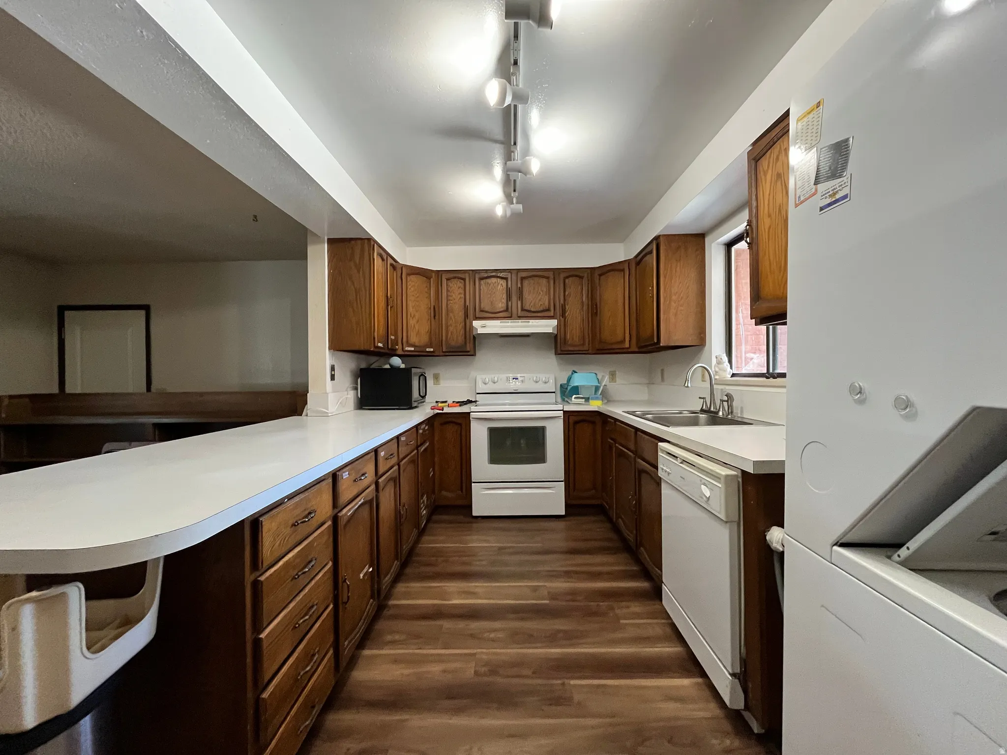 Kitchen featuring wood-finish cabinetry, white countertops, and wood-finish flooring