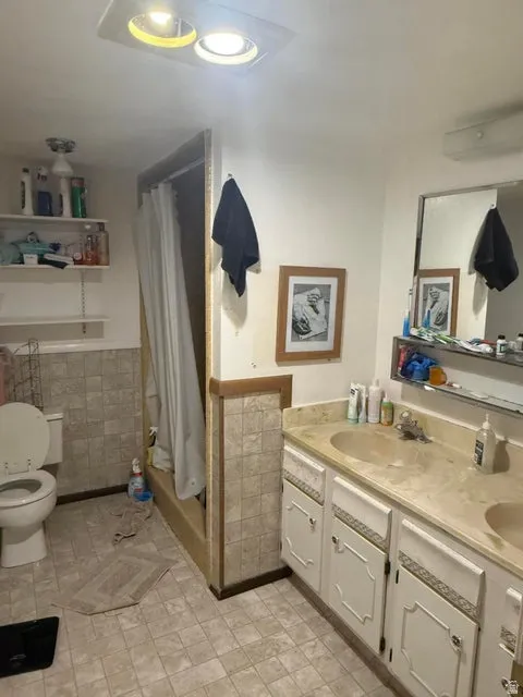 Bathroom featuring a dual-sink vanity with light-toned countertops and white cabinetry